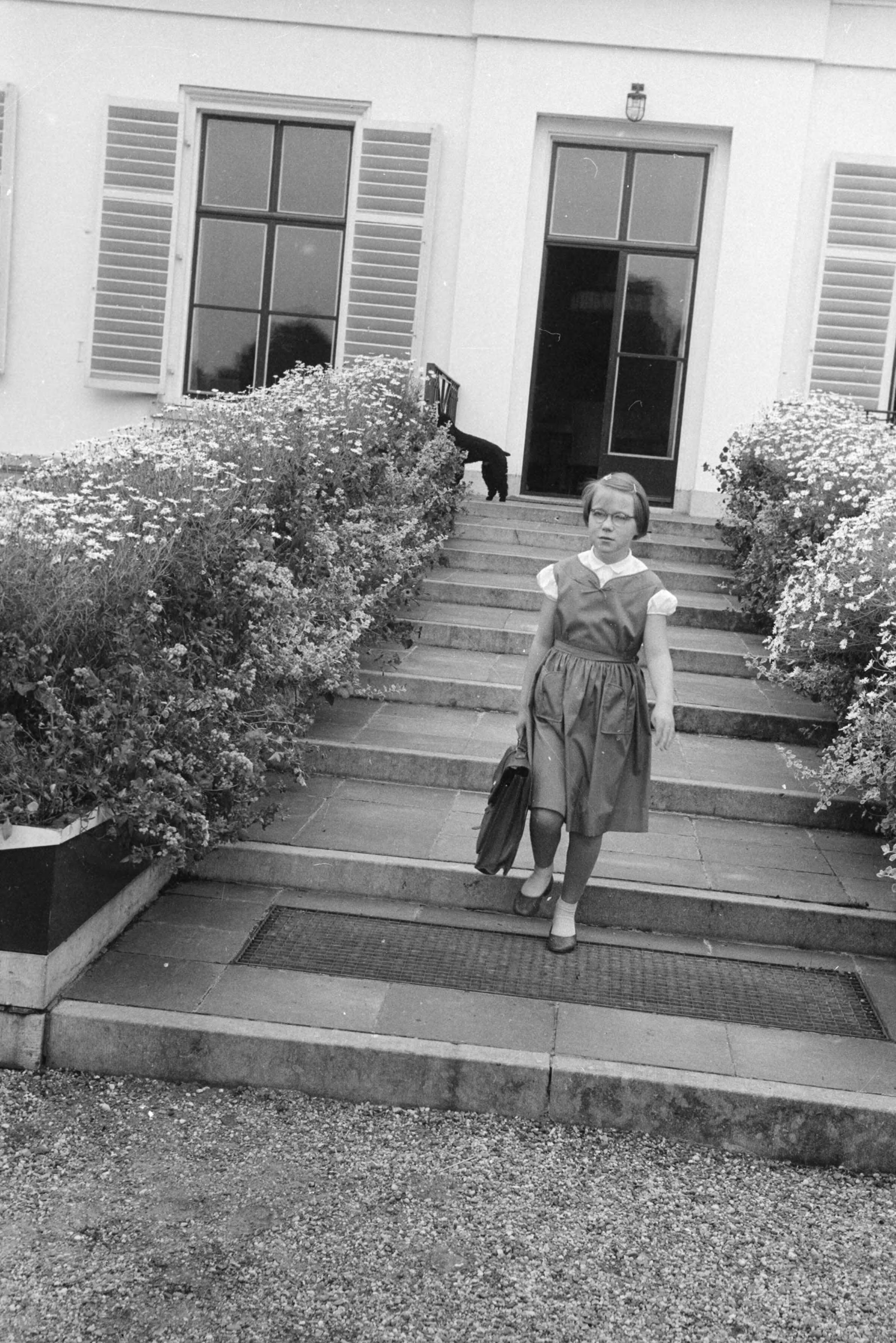 Fotocollectie RVD / Koninklijk Huis — Prinses Marijke (Christina) met schooltas aan achterzijde van paleis Soestdijk, 1956 — Foto: Rousel (repro) / RVD. Licentie: Set B: Rechtenvrij / Publiek Domein. Bron: Nationaal Archief. http://hdl.handle.net/10648/afb682b4-d0b4-102d-bcf8-003048976d84