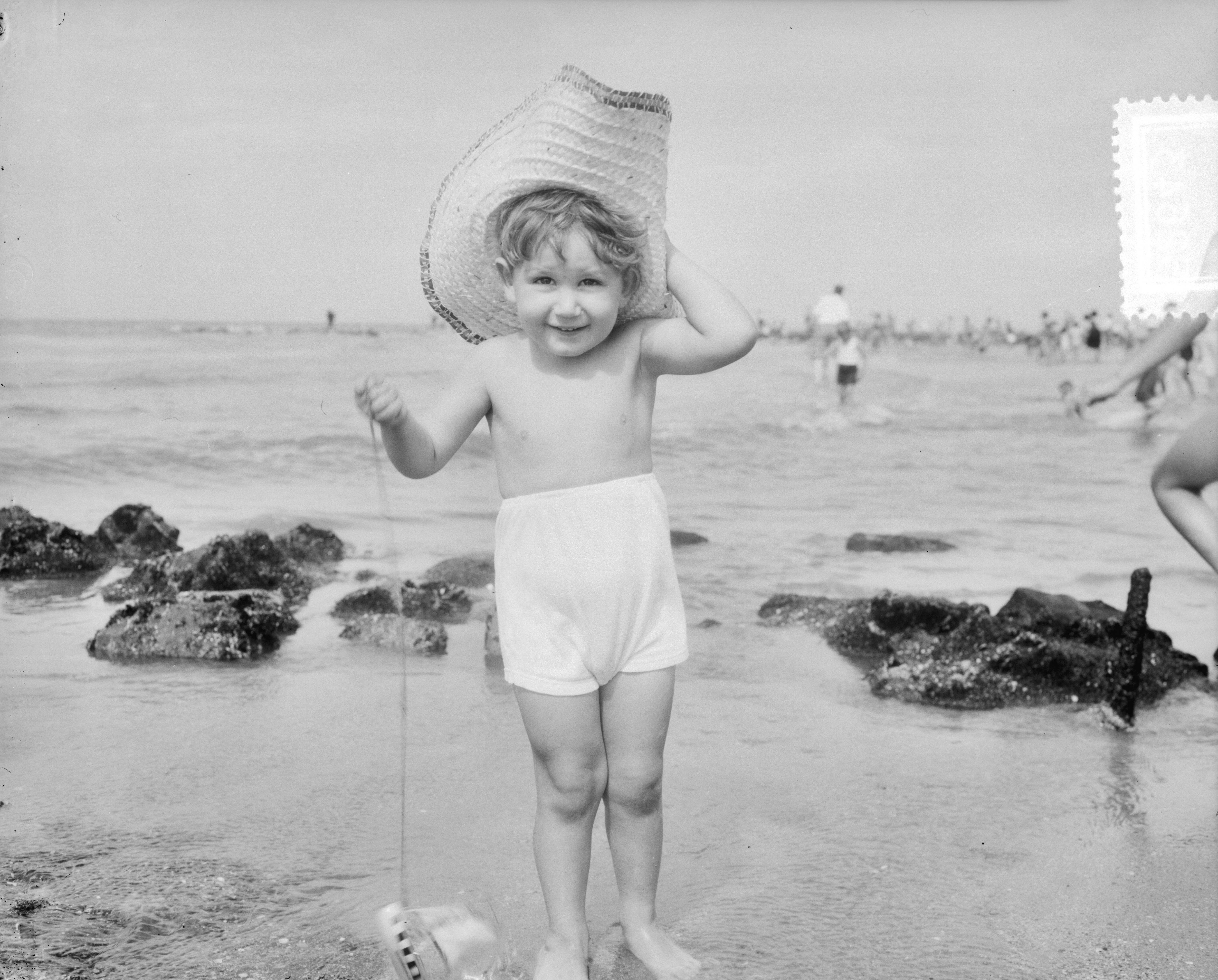 Fotocollectie Anefo — Strandplaatjes Scheveningen. Kind met zonnehoed — Foto: Consenheim, Wim / Anefo. Licentie: Set B: Rechtenvrij / Publiek Domein. Bron: Nationaal Archief. http://hdl.handle.net/10648/a8fe50b4-d0b4-102d-bcf8-003048976d84