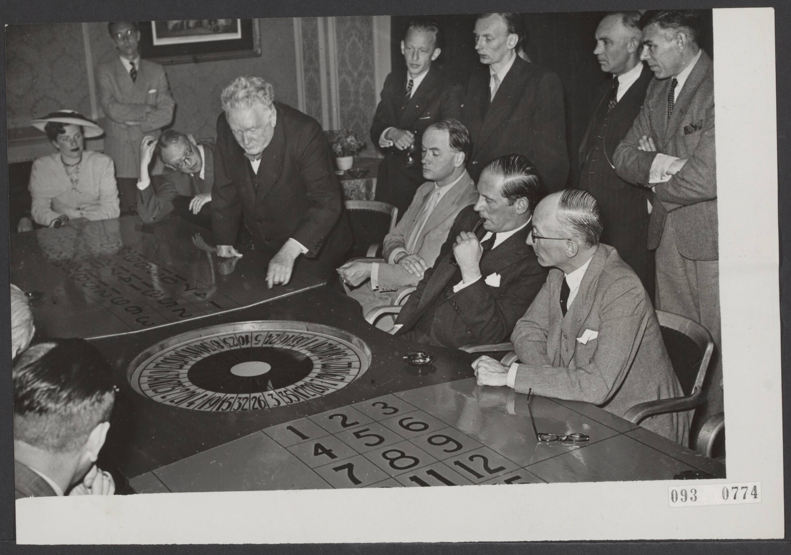 Fotocollectie Elsevier Binnenland — In het Casino te Scheveningen werd een demonstratie gegeven met een nieuw behendigheidsspel. Tijdens de demonstratie vlnr. staande prof. F. Schuh, de burgemeester van Noordwijk G.F.W. van Berckel, de burgemeester van den Haag mr. W.A.J. Visser en de burgemeester van Zandvoort, H. van Fenema — Foto: ANP / RVD of rechtenvrij. Licentie: Set B: Rechtenvrij / Publiek Domein. Bron: Nationaal Archief. http://hdl.handle.net/10648/ae293b80-d0b4-102d-bcf8-003048976d84