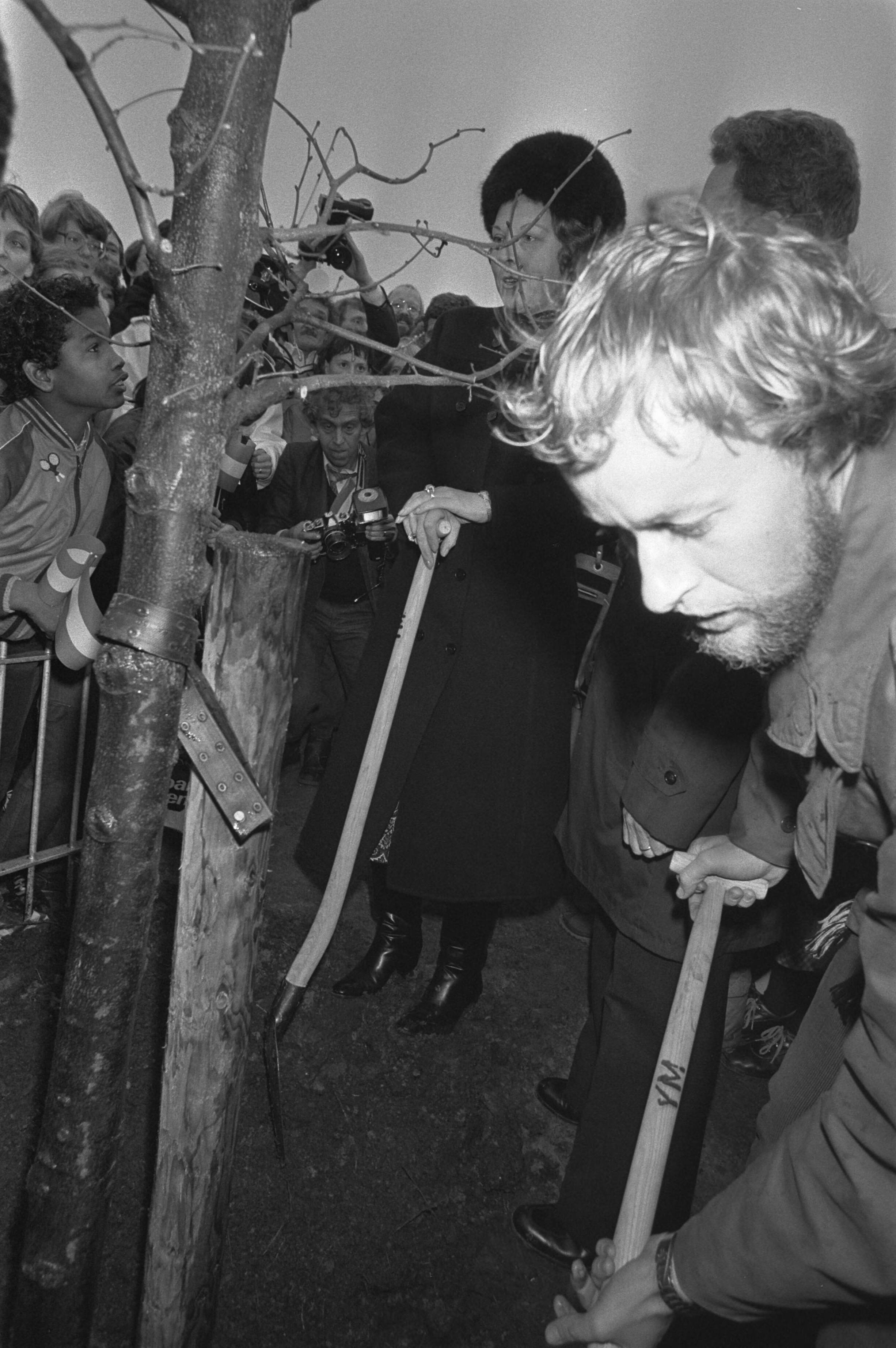 Koningin Beatrix bezoekt Almere in verband met het 5-jarig bestaan — Koningin Beatrix plant een boom in Almere — Foto: Croes, Rob C. / Anefo. Licentie: Set B: Rechtenvrij / Publiek Domein. Bron: Nationaal Archief. http://hdl.handle.net/10648/ad0a007c-d0b4-102d-bcf8-003048976d84
