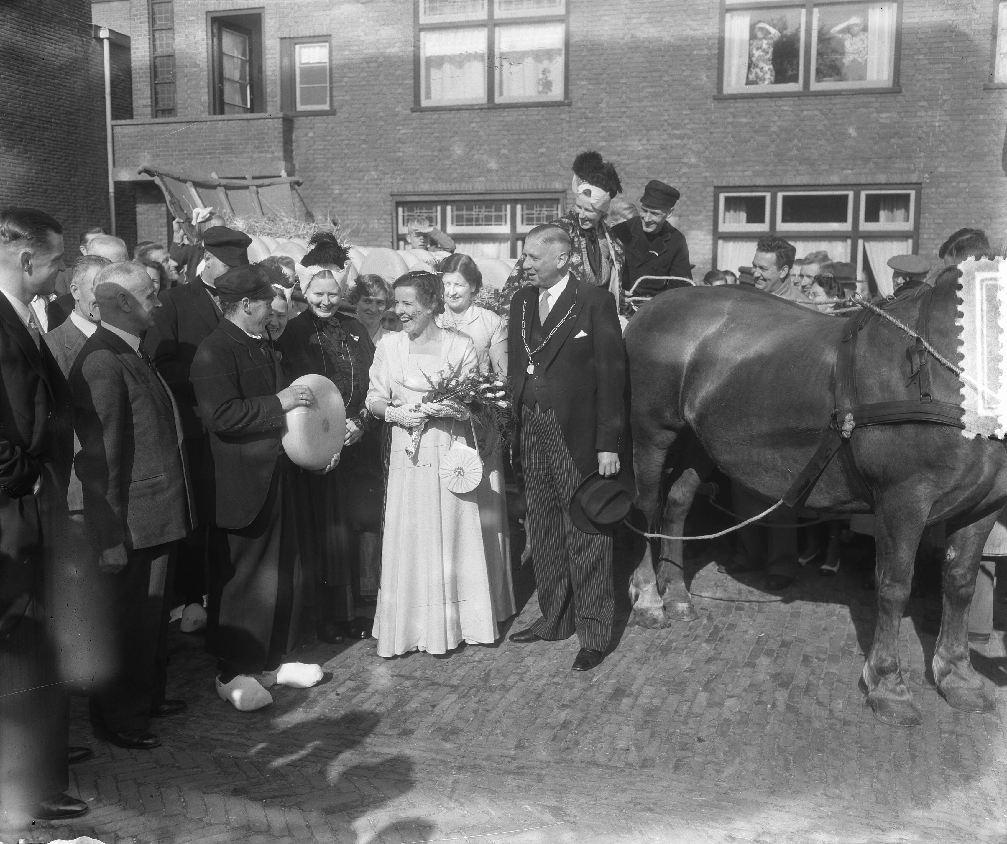Fotocollectie Anefo — Kaaskoningin Lien I lacht tijdens haar rondgang doorn Bodegraven als haar een kaas wordt aangeboden. Naast haar de burgemeester van Bodegraven J.J. Croles — Foto: Pot, Harry / Anefo. Licentie: Set B: Rechtenvrij / Publiek Domein. Bron: Nationaal Archief. http://hdl.handle.net/10648/a8ff606c-d0b4-102d-bcf8-003048976d84