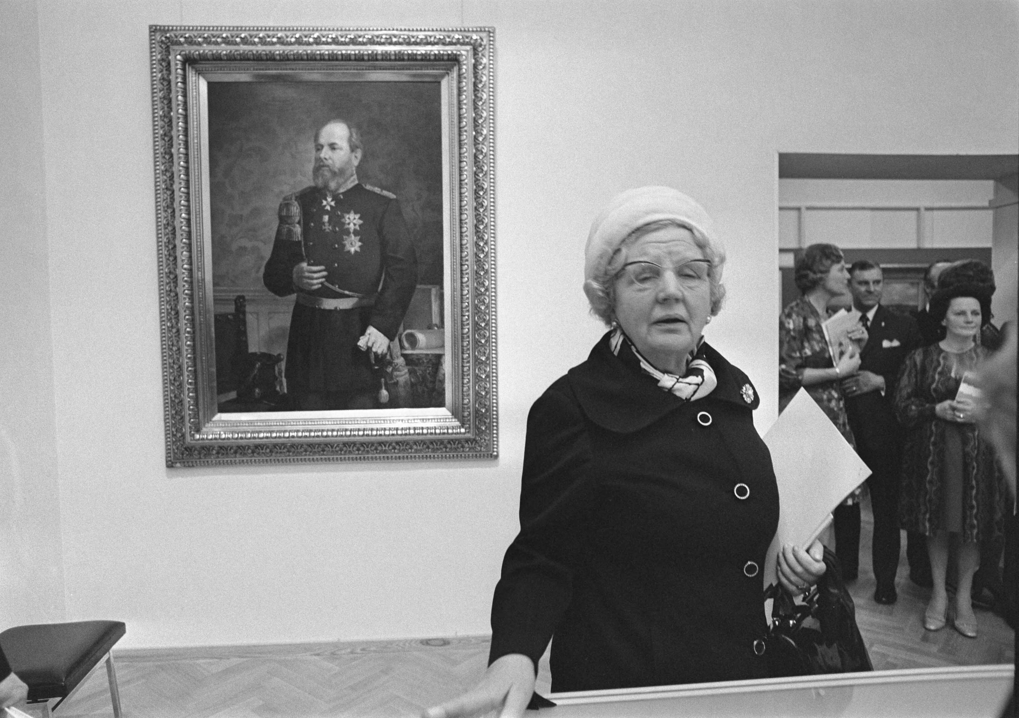 Fotocollectie Anefo — Koningin Juliana is op de tentoonstelling 'Luxemburg onder Oranje-Nassau 1815-1890' in het Gemeentemuseum te Den Haag. Op de achtergrond een portret van koning Willem III — Foto: Mieremet, Rob / Anefo. Licentie: Set B: Rechtenvrij / Publiek Domein. Bron: Nationaal Archief. http://hdl.handle.net/10648/ac5a8340-d0b4-102d-bcf8-003048976d84