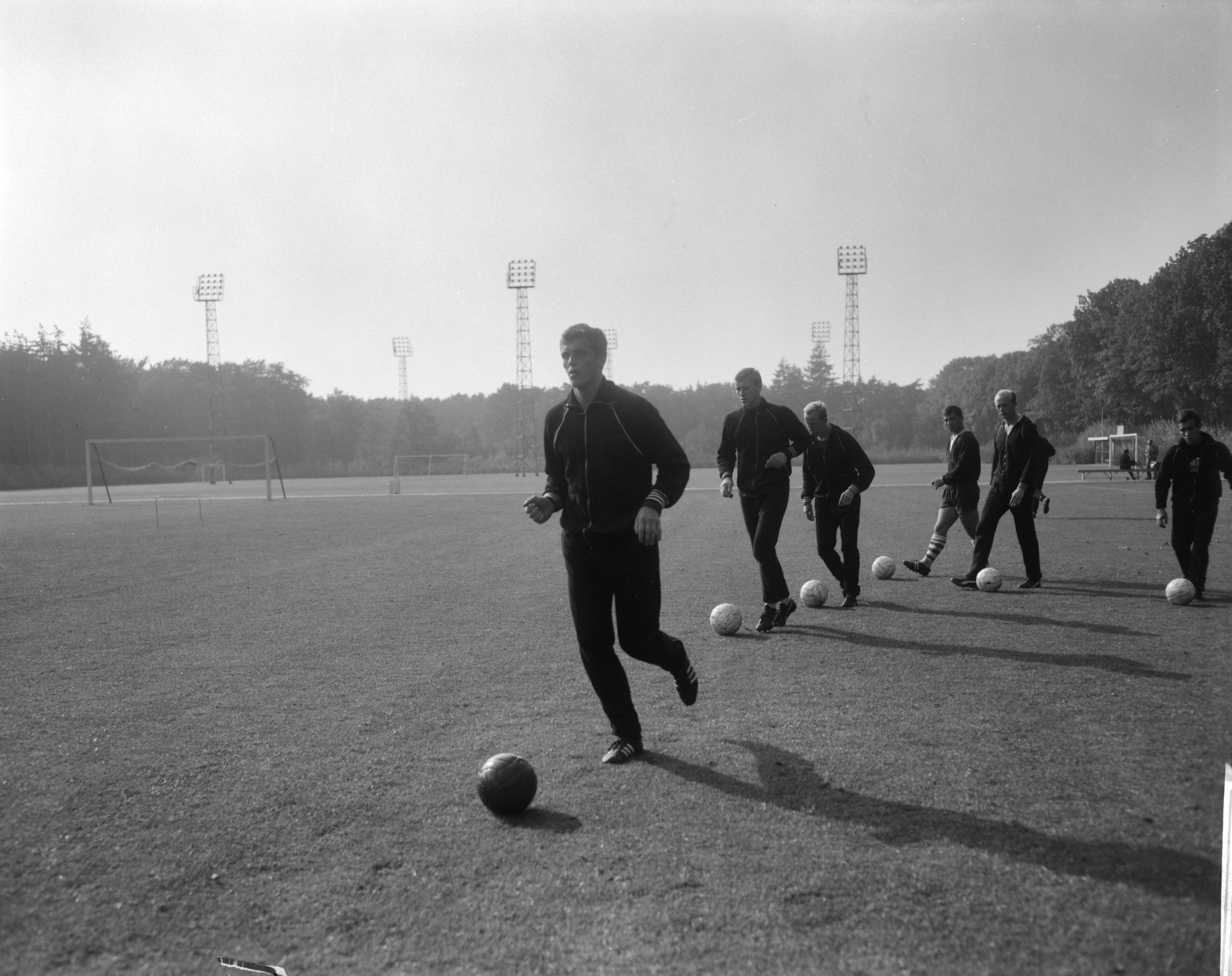Training van het Nederlands elftal op het sportcentrum van de KNVB te Zeist — Spelers tijdens de training, Piet Keizer voorop, gevolgd door Doesburg, Groot, Laseroms, Kruiver en Flinkevleugel — Foto: Bilsen, Joop van / Anefo. Licentie: Set B: Rechtenvrij / Publiek Domein. Bron: Nationaal Archief. http://hdl.handle.net/10648/aac630b0-d0b4-102d-bcf8-003048976d84