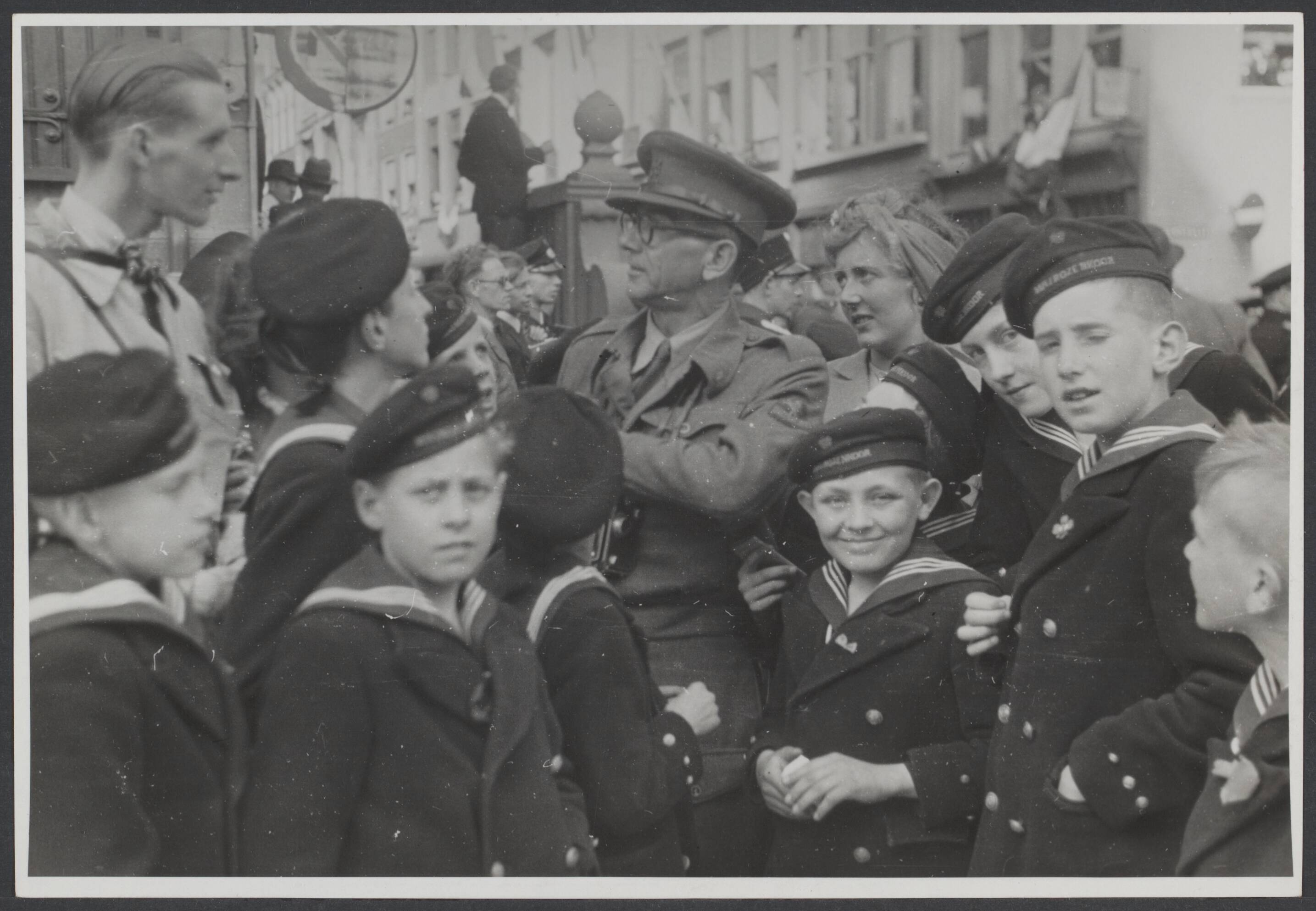 Bevrijding 's Gravenhage (Den Haag) — Een geallieerde legerfotograaf omringd door knapen van het matrozenkoor, tijdens de intocht der Canadezen te Den Haag, Nederland 1945. — Foto: Wal, J.Th. A. van der / Spaarnestad. Licentie: Set B: Rechtenvrij / Publiek Domein. Bron: Nationaal Archief. http://hdl.handle.net/10648/d053a148-0dd7-dc7f-ff6f-03fed1b2225c
