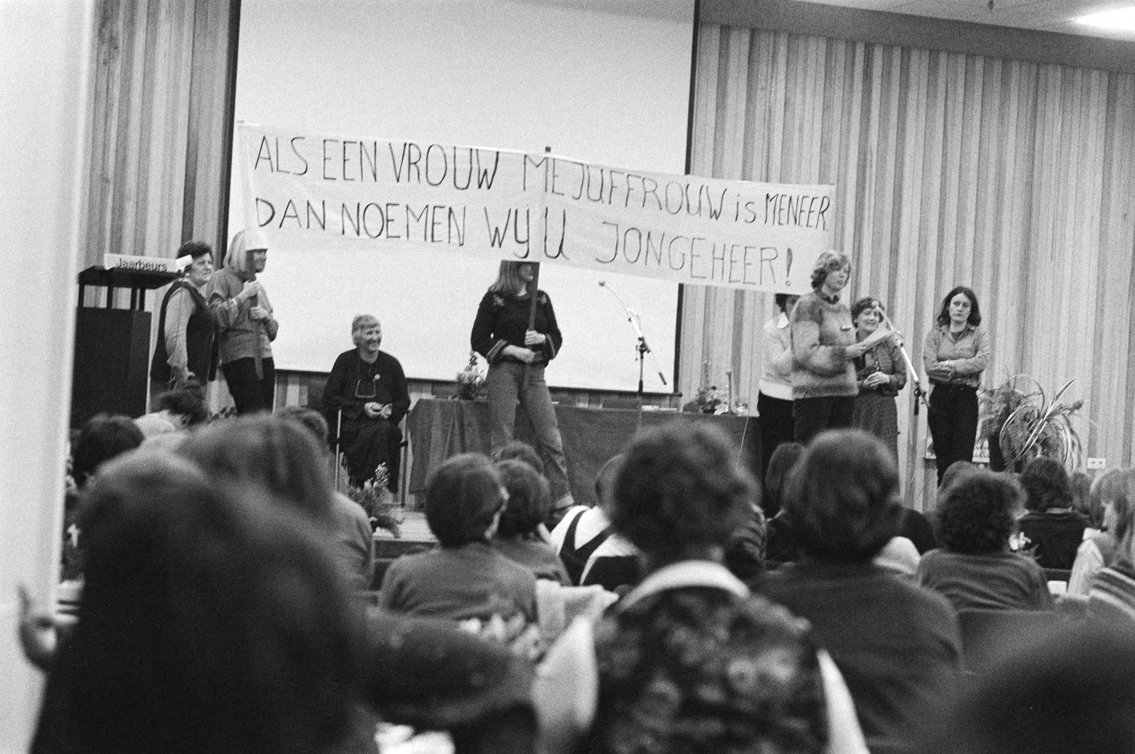 Fotocollectie Anefo — Bijeenkomst Rooie Vrouwen in Utrecht i.v.m. de Wet op d Seksediscriminatie; zaaloverzicht — Foto: Suyk, Koen / Anefo. Licentie: Set B: Rechtenvrij / Publiek Domein. Bron: Nationaal Archief. http://hdl.handle.net/10648/acdbba64-d0b4-102d-bcf8-003048976d84