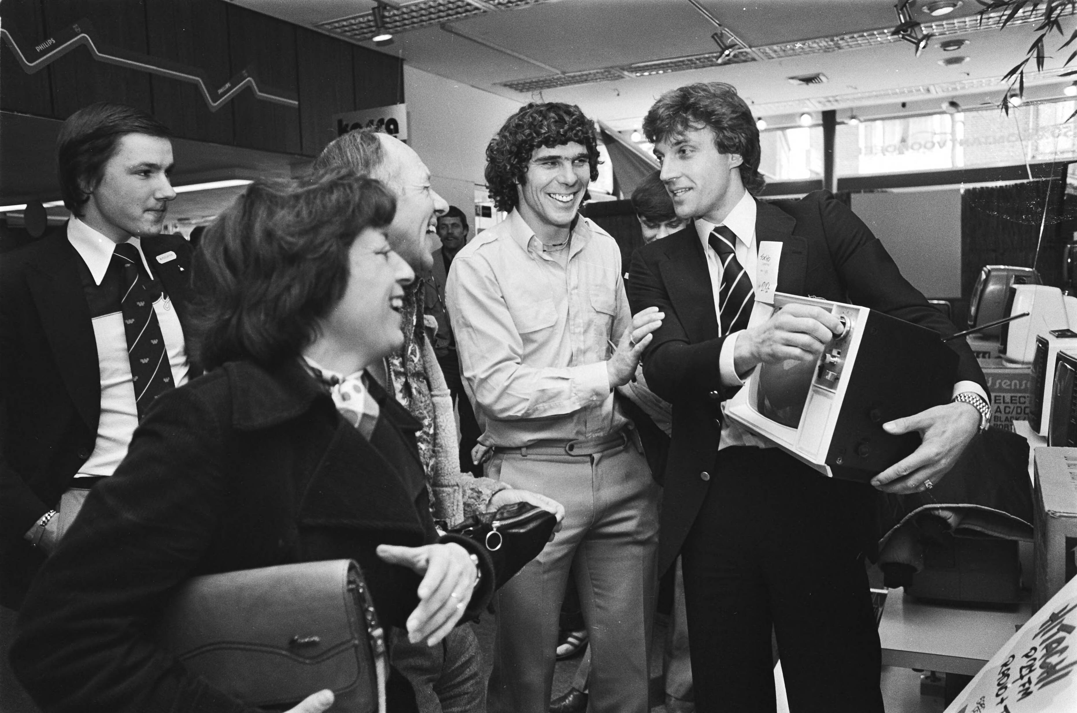 Fotocollectie Anefo — Krol en Van Hanegem op bezoek bij WK-sponsor Wastora in Zaandam; Ruud Krol (r) en Willem van Hanegem verkopen een televisie — Foto: Peters, Hans / Anefo. Licentie: Set B: Rechtenvrij / Publiek Domein. Bron: Nationaal Archief. http://hdl.handle.net/10648/acb13aaa-d0b4-102d-bcf8-003048976d84