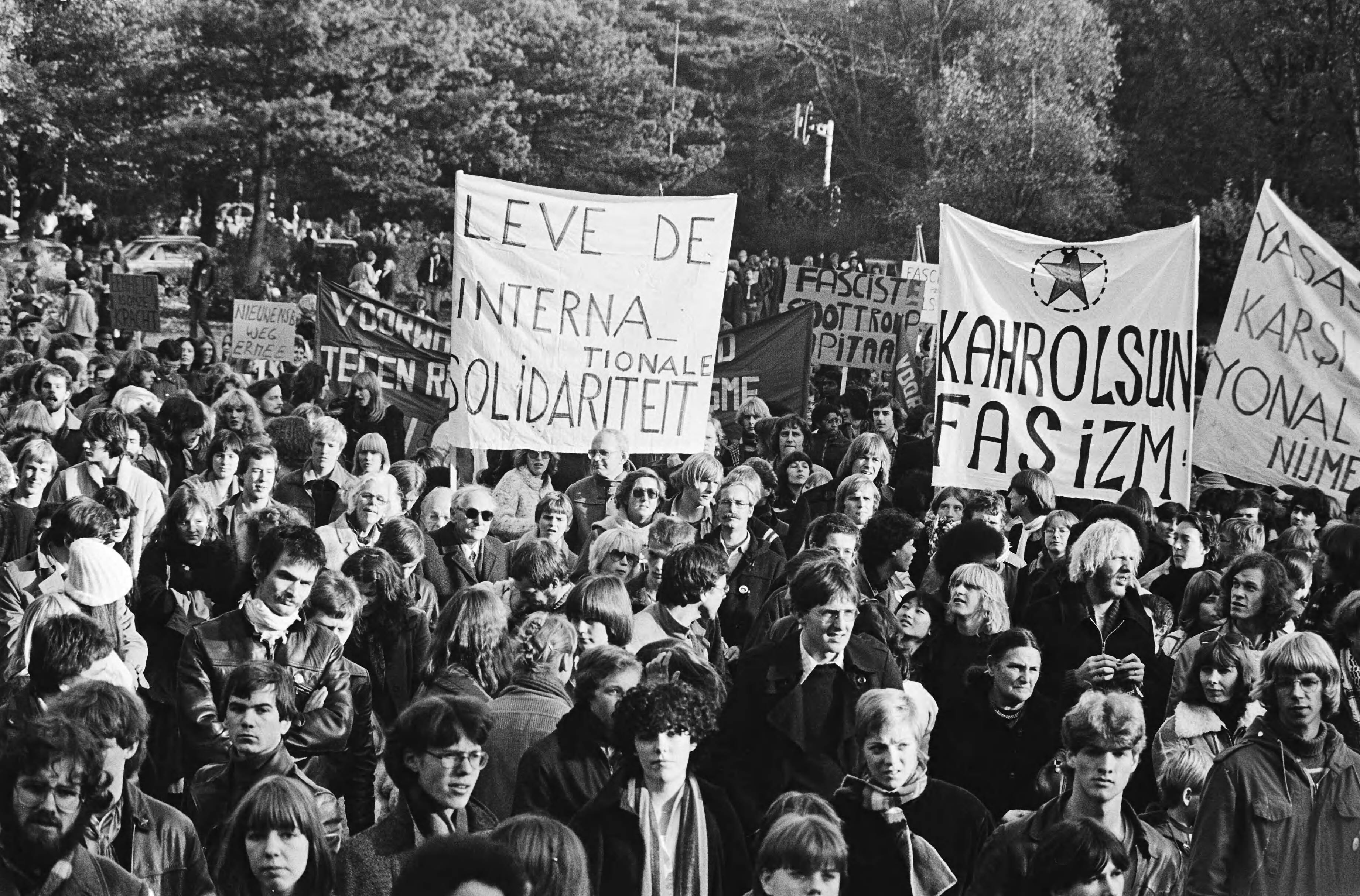 Manifestatie in de bossen van Soestduinen tegen het neofascisme — Demonstranten met spandoeken; o.a. "Leve de internationale solidariteit" en "Kahrolsun Fasizm" (weg met het fascisme) — Foto: Suyk, Koen / Anefo. Licentie: Set B: Rechtenvrij / Publiek Domein. Bron: Nationaal Archief. http://hdl.handle.net/10648/acd3a86a-d0b4-102d-bcf8-003048976d84