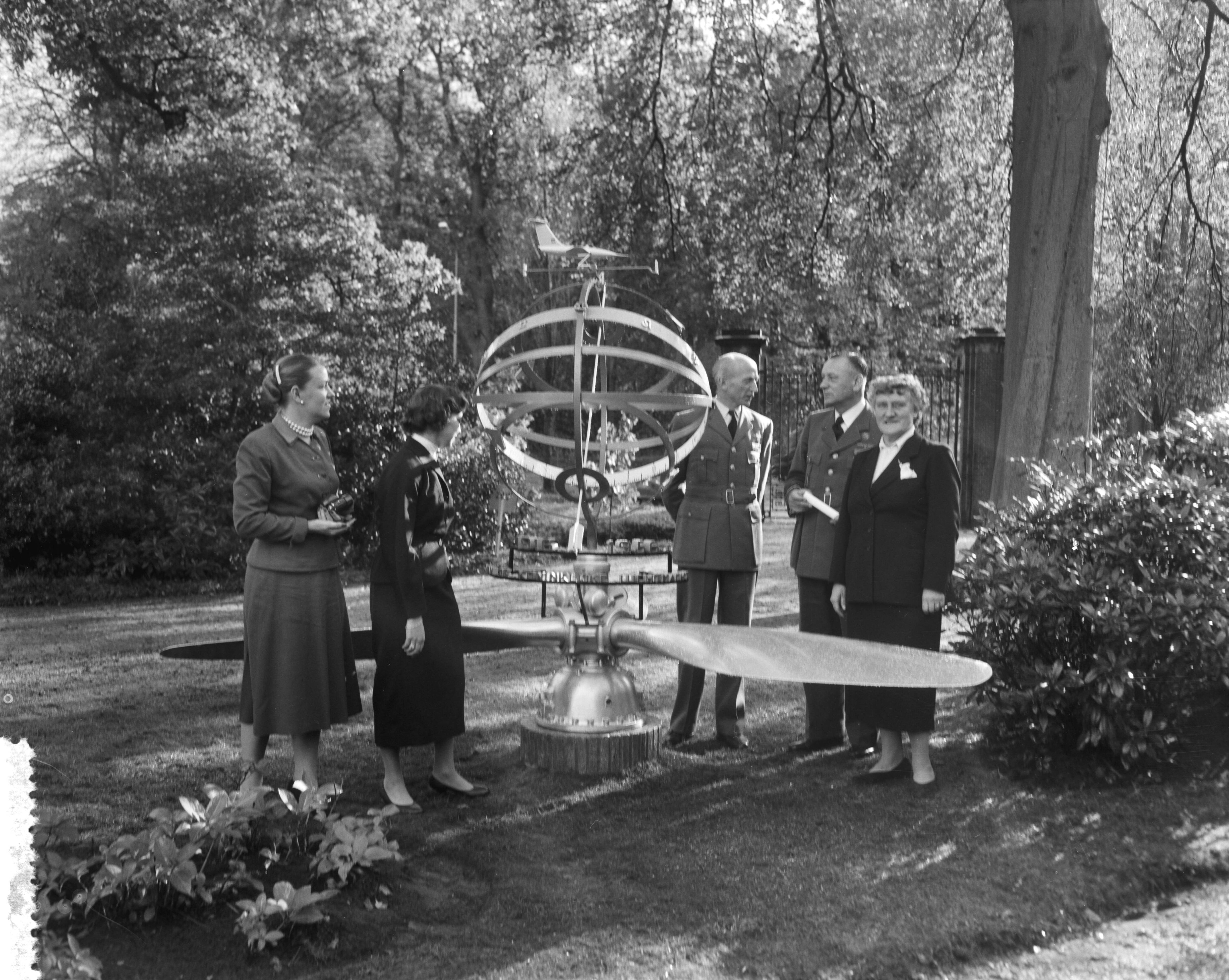 Fotocollectie Anefo — Een deputatie van de Koninklijke Luchtmacht heeft aan de scheidende luitenant-generaal-waarnemer Anton Baretta, chef Luchtmachtstaf, een door J.F. Doeve ontworpen zonnewijzer aangeboden. In de tuin van landgoed De Hartekamp te Wassenaar, vlnr. twee dochters van de generaal (Eaklin-Baretta en Tazelaar-Baretta), generaal-majoor H. Schaper, luitenant-generaal A. Baretta, mevr. Baretta-De Bruyn — Foto: Pot, Harry / Anefo. Licentie: Set B: Rechtenvrij / Publiek Domein. Bron: Nationaal Archief. http://hdl.handle.net/10648/a951997c-d0b4-102d-bcf8-003048976d84
