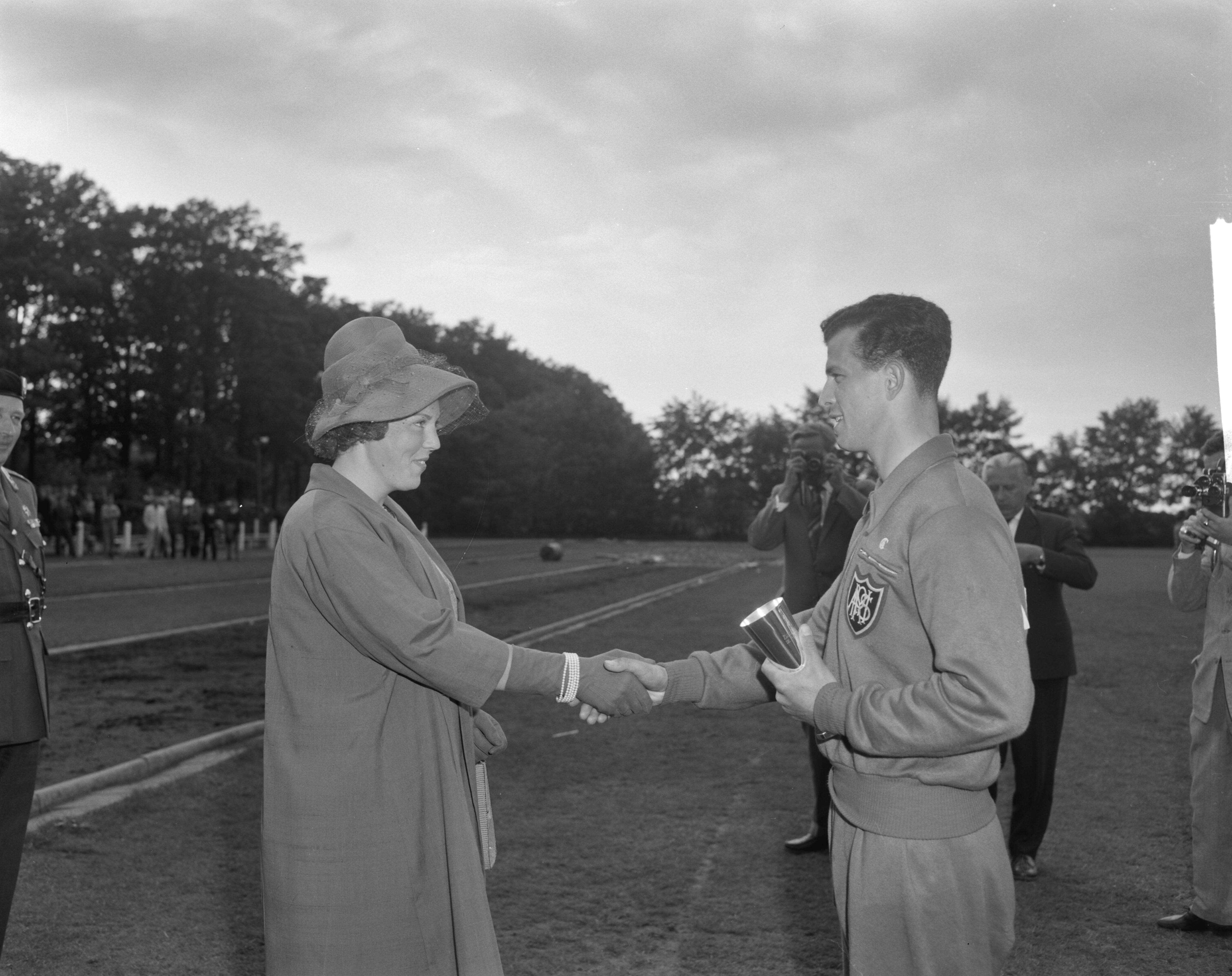 Fotocollectie Anefo — West-Europese kadetten-atletiekwedstrijden in Breda. Prinses Beatrix reikt, in plaats van prins Bernhard, een beker uit — Foto: Bilsen, Joop van / Anefo. Licentie: Set B: Rechtenvrij / Publiek Domein. Bron: Nationaal Archief. http://hdl.handle.net/10648/aa0cb6ee-d0b4-102d-bcf8-003048976d84