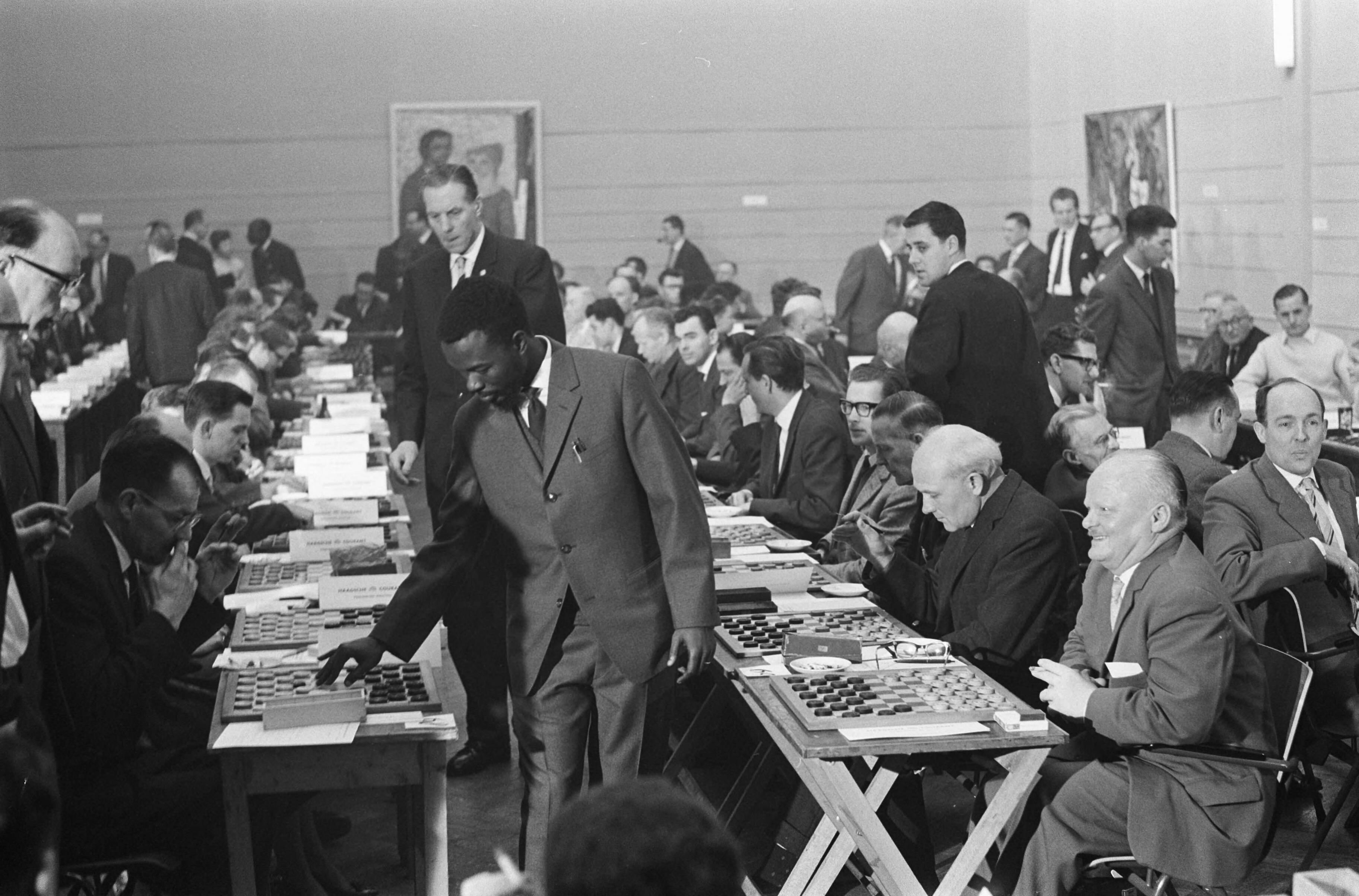 Fotocollectie Anefo — Wereldrecord simultaandammen van Baba Sy in Den Haag . Baba Sy tijdens de simultaanseance — Foto: Rossem, Wim van / Anefo. Licentie: Set B: Rechtenvrij / Publiek Domein. Bron: Nationaal Archief. http://hdl.handle.net/10648/a9f63ae0-d0b4-102d-bcf8-003048976d84