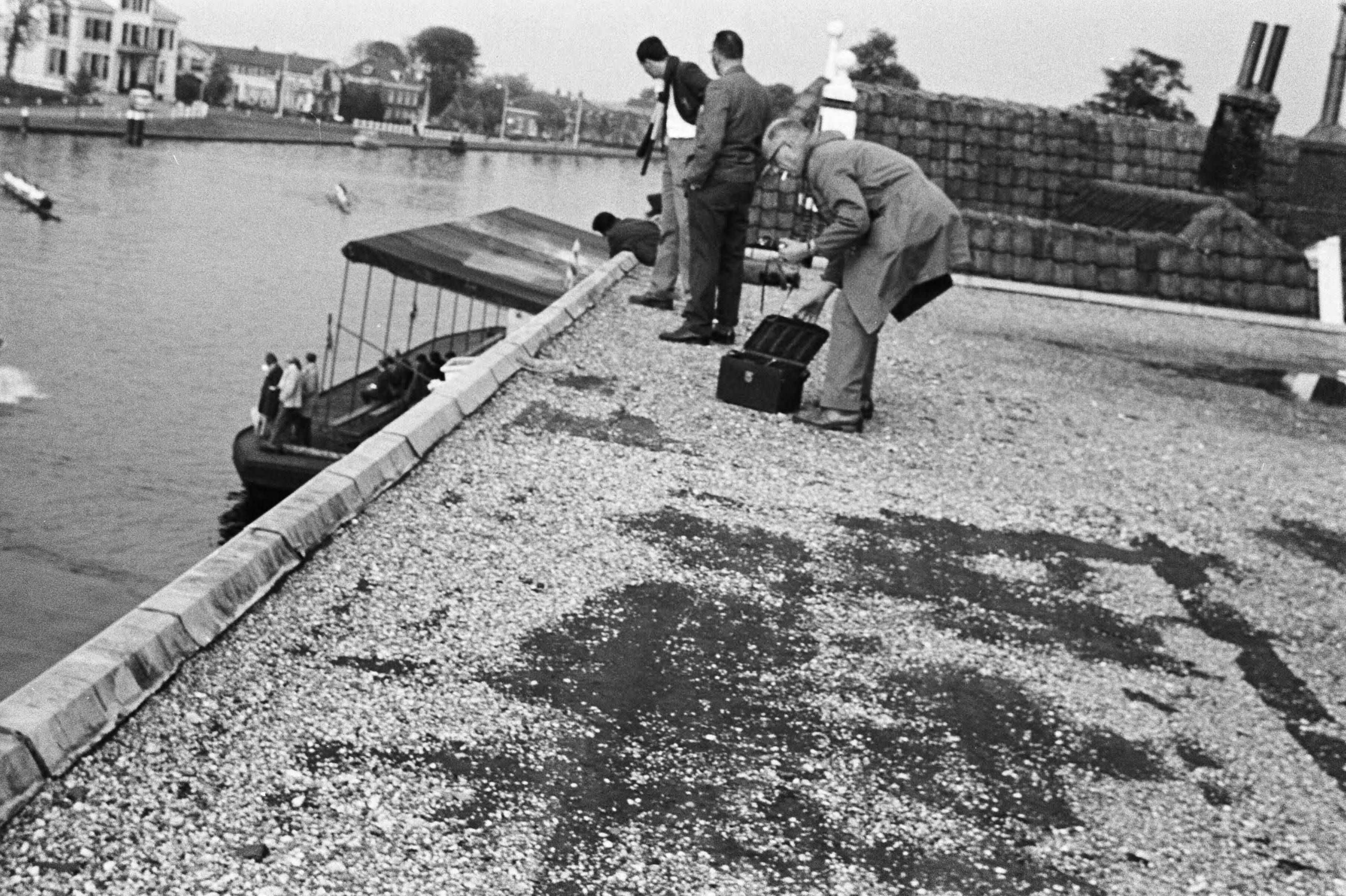Fotocollectie Anefo — Roeien op de Oude Rijn in Alphen aan de Rijn. Een fotograaf (?) opent een koffer staande op een plat dak — Foto: Koch, Eric / Anefo. Licentie: Set B: Rechtenvrij / Publiek Domein. Bron: Nationaal Archief. http://hdl.handle.net/10648/aa38079a-d0b4-102d-bcf8-003048976d84