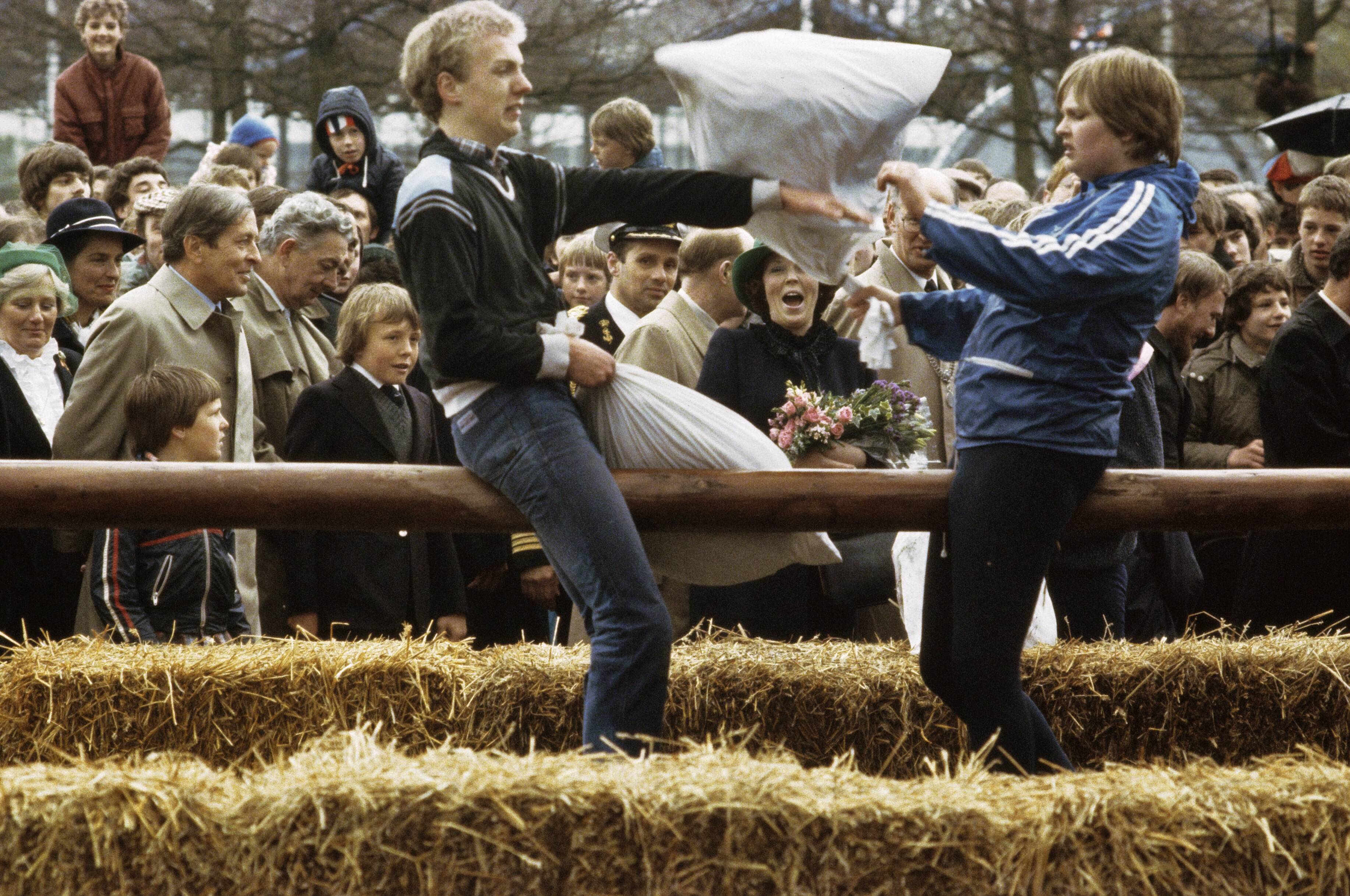 Fotocollectie Anefo — Koninginnedag: Koninklijke Familie bezoekt Harlingen en Zuidlaren; kussengevecht in Zuidlaren, op achtergrond Claus en Beatrix — Foto: Dijk, Hans van / Anefo. Licentie: Set B: Rechtenvrij / Publiek Domein. Bron: Nationaal Archief. http://hdl.handle.net/10648/ad8b122a-d0b4-102d-bcf8-003048976d84