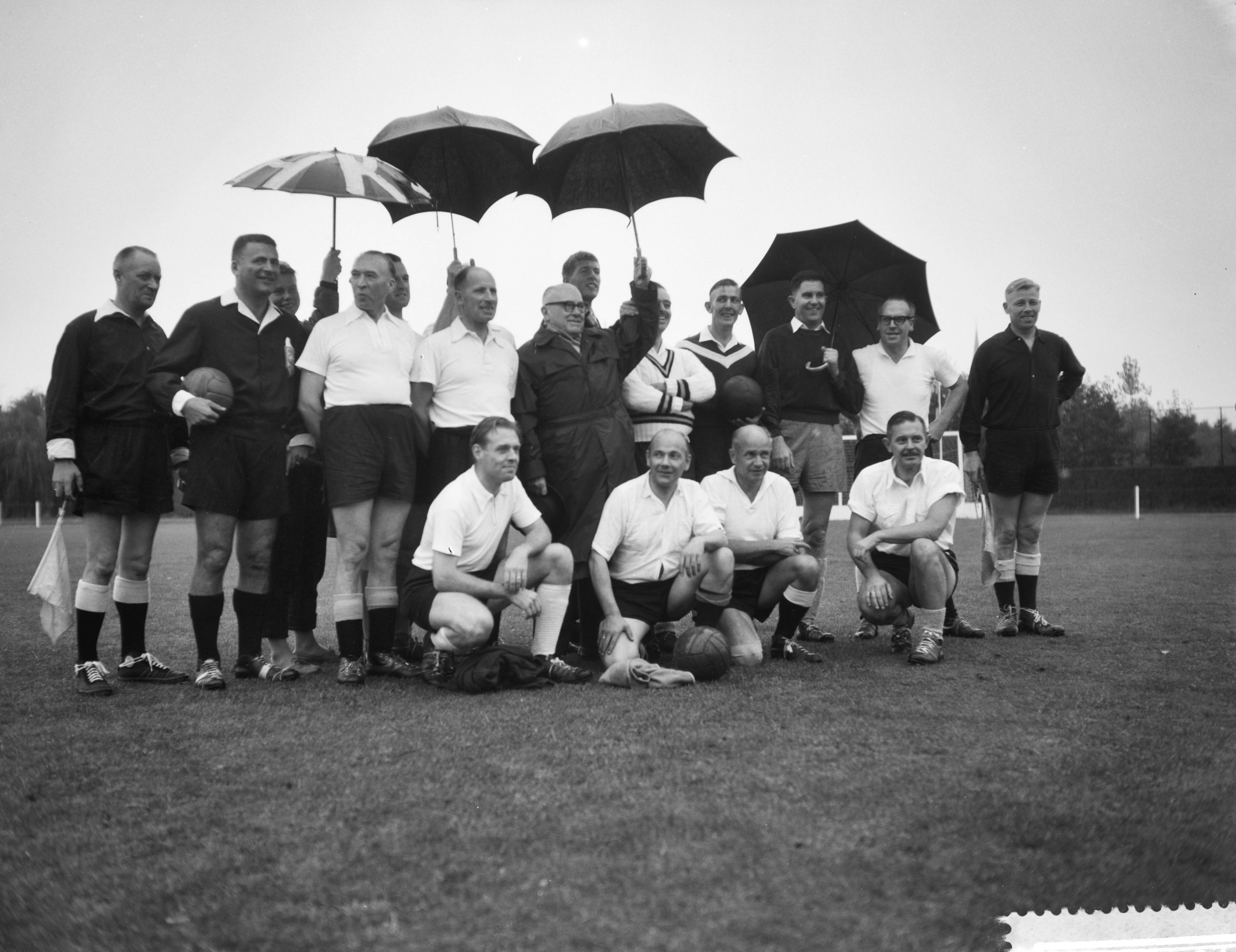 Fotocollectie Anefo — Interparlementair voetbal. Holland tegen België op sportpark Te Werve in Rijswijk. Aanhangers houden de spelers droog — Foto: Rossem, Wim van / Anefo. Licentie: Set B: Rechtenvrij / Publiek Domein. Bron: Nationaal Archief. http://hdl.handle.net/10648/a9a00094-d0b4-102d-bcf8-003048976d84