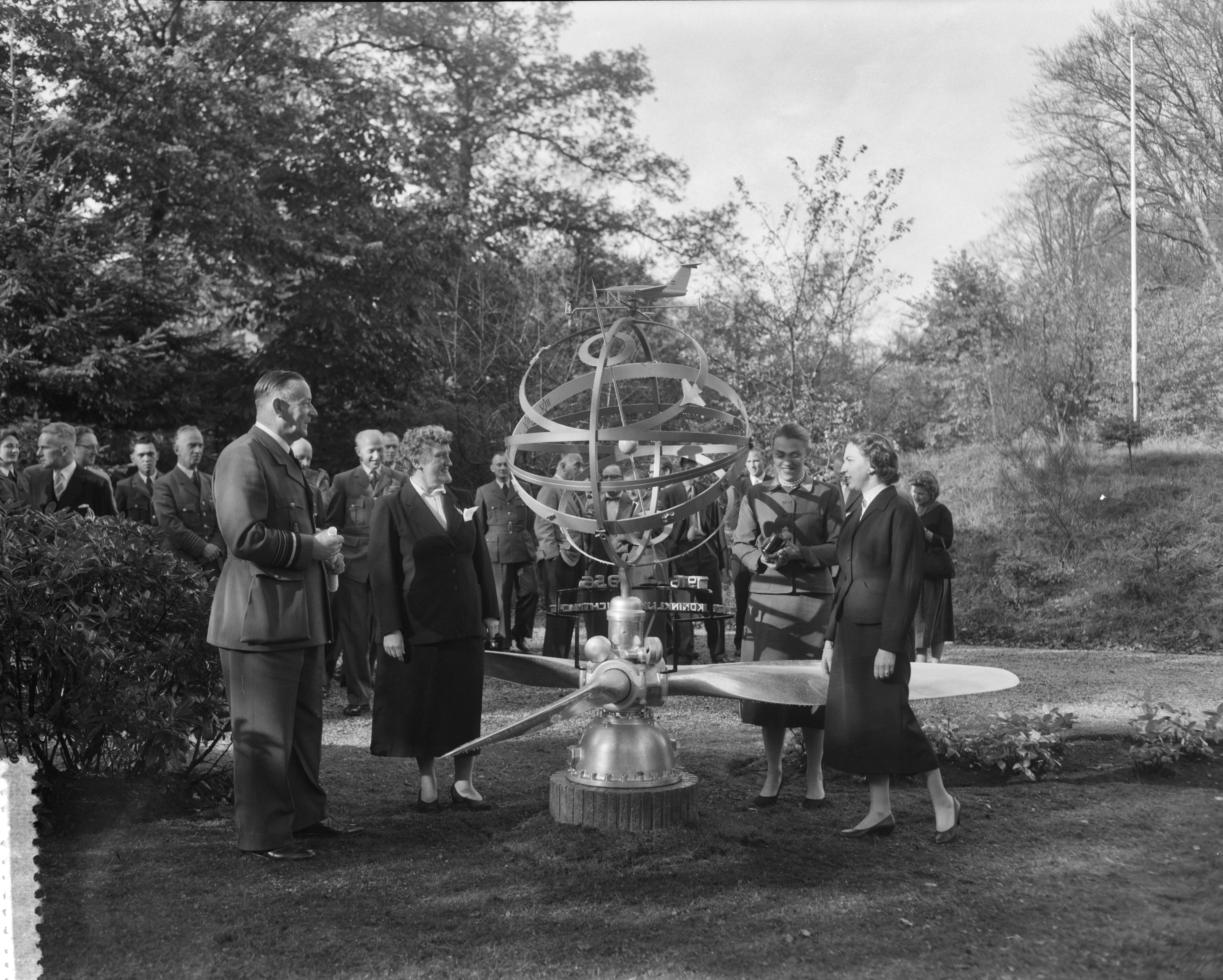 Fotocollectie Anefo — Een deputatie van de Koninklijke Luchtmacht heeft aan de scheidende luitenant-generaal-waarnemer Anton Baretta, chef Luchtmachtstaf, een door J.F. Doeve ontworpen zonnewijzer aangeboden. In de tuin van landgoed De Hartekamp te Wassenaar, vlnr. luitenant-generaal A. Baretta, mevr. Baretta-De Bruyn en twee dochters van de generaal (Eaklin-Baretta en Tazelaar-Baretta), generaal-majoor H. Schaper, — Foto: Pot, Harry / Anefo. Licentie: Set B: Rechtenvrij / Publiek Domein. Bron: Nationaal Archief. http://hdl.handle.net/10648/a9519bb6-d0b4-102d-bcf8-003048976d84