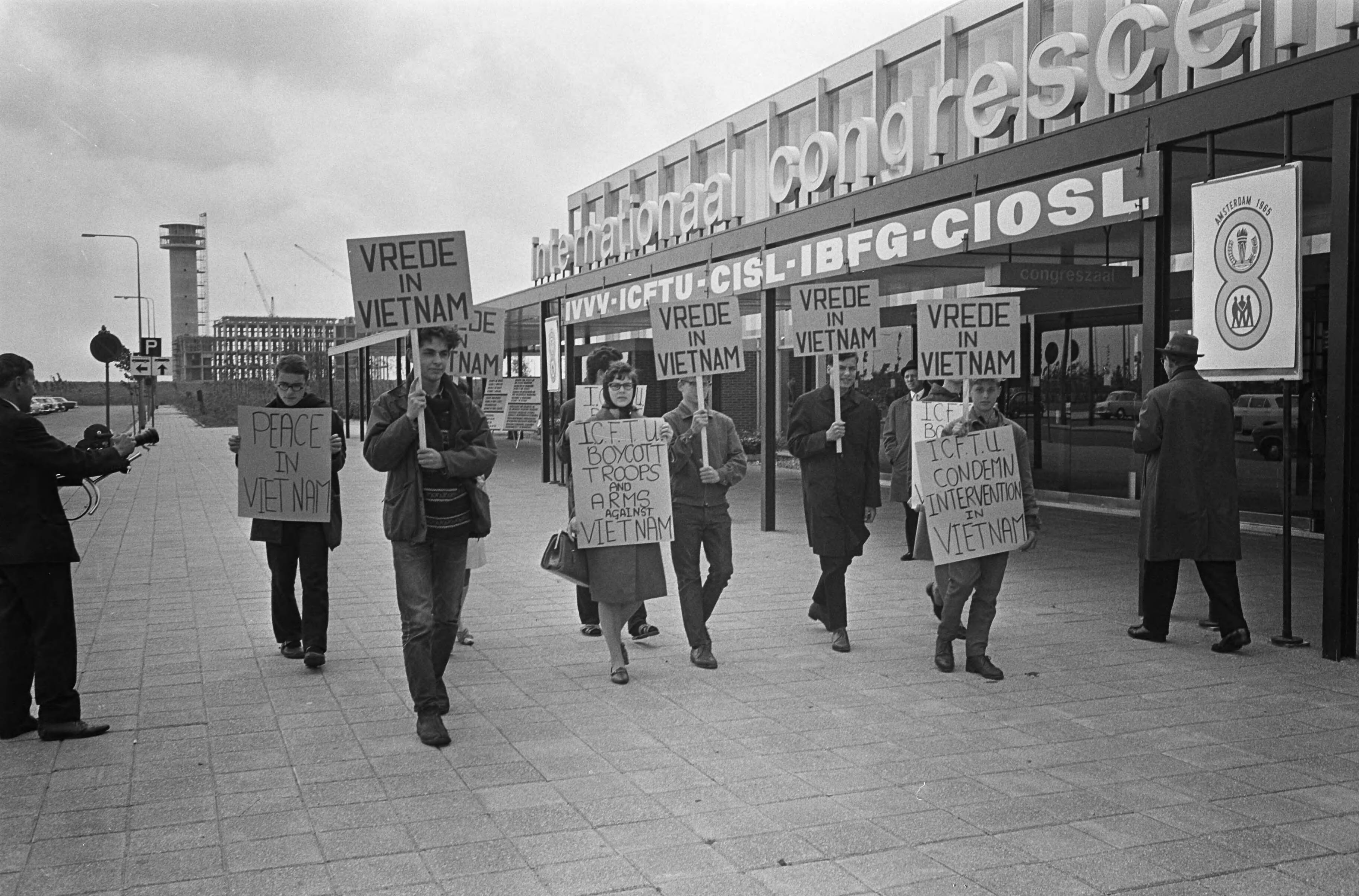 Fotocollectie Anefo — Wereldcongres Vakbeweging in de RAI te Amsterdam, voor de ingang werd gedemonstreerd tegen de oorlog in Vietnam — Foto: Koch, Eric / Anefo. Licentie: Set B: Rechtenvrij / Publiek Domein. Bron: Nationaal Archief. http://hdl.handle.net/10648/aab2b8fa-d0b4-102d-bcf8-003048976d84