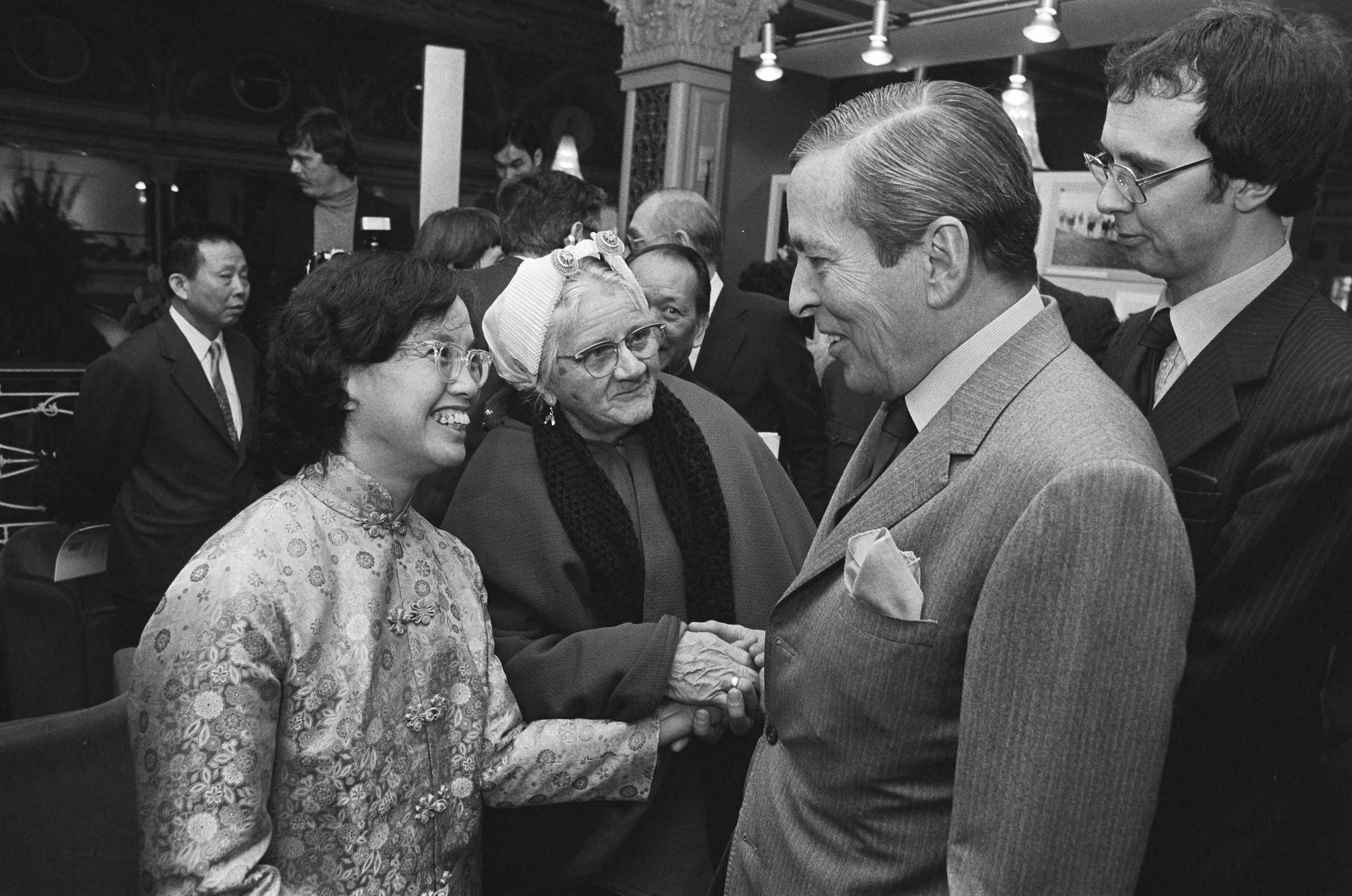 Fotocollectie Anefo — Claus woonde opening van fototent. "China Nu" in het Kurhaus te Scheveningen bij. Chinese en Scheveningse vrouwen in klederdracht — Foto: Antonisse, Marcel / Anefo. Licentie: Set B: Rechtenvrij / Publiek Domein. Bron: Nationaal Archief. http://hdl.handle.net/10648/ad0f99c4-d0b4-102d-bcf8-003048976d84