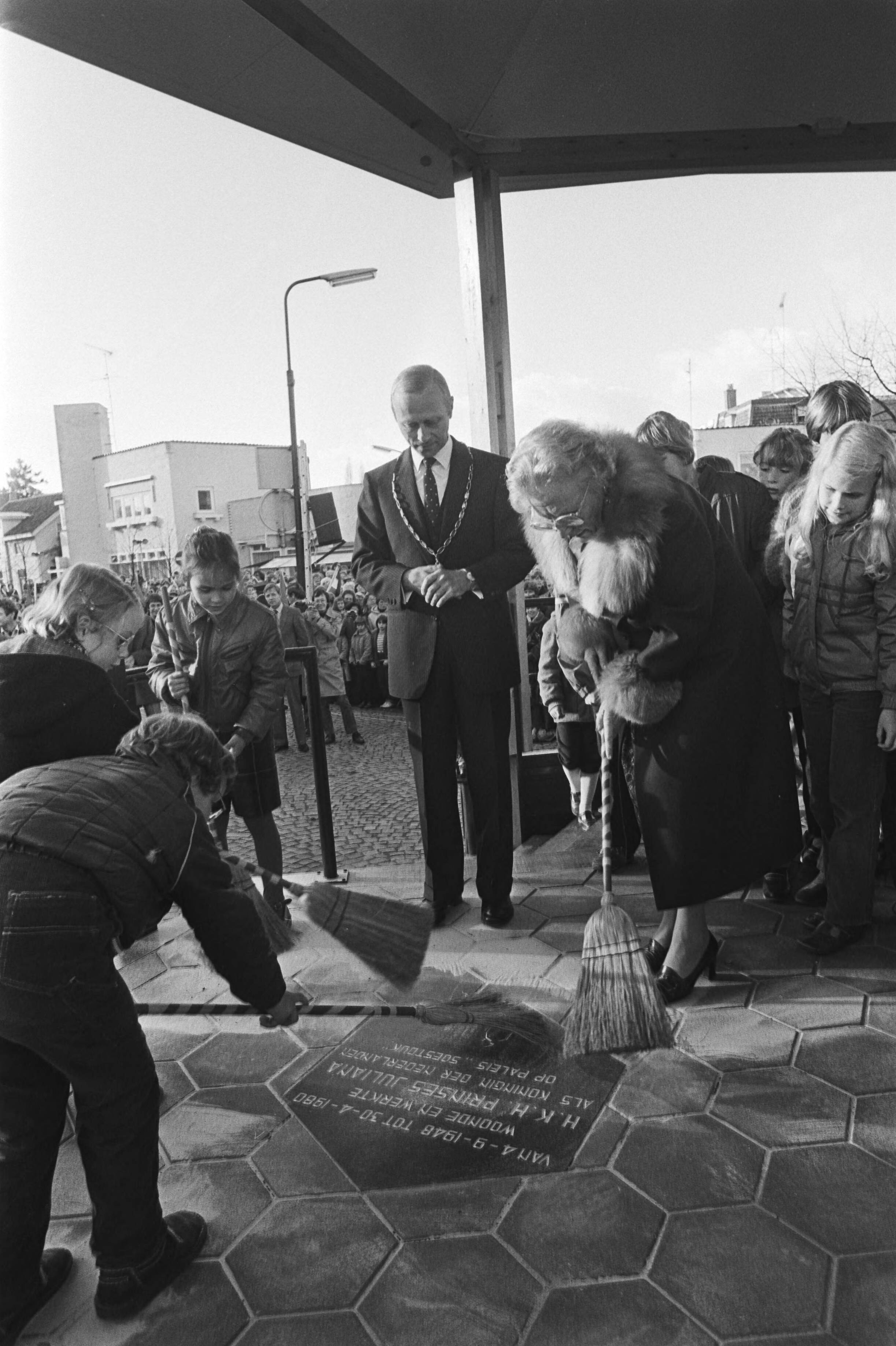 Prinses Juliana heeft in Baarn de muziektent op de Brink officiëel in gebruik — Prinses Juliana veegt, samen met enkele kinderen, zand van de herinneringstegel — Foto: Dijk, Hans van / Anefo. Licentie: Set B: Rechtenvrij / Publiek Domein. Bron: Nationaal Archief. http://hdl.handle.net/10648/ad085b8c-d0b4-102d-bcf8-003048976d84