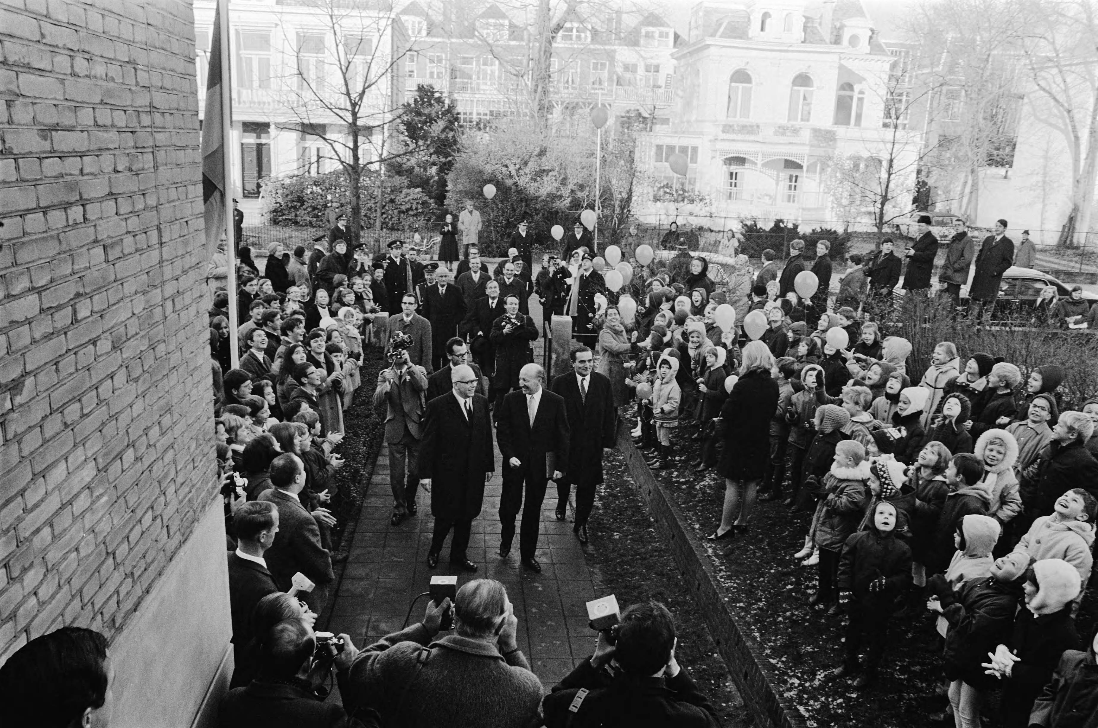 Fotocollectie Anefo — President Heinemann bezoekt Duitse school in Den Haag . President Heinemann loopt door haag van kinderen met balonnen — Foto: Verhoeff, Bert / Anefo. Licentie: Set B: Rechtenvrij / Publiek Domein. Bron: Nationaal Archief. http://hdl.handle.net/10648/ab837896-d0b4-102d-bcf8-003048976d84