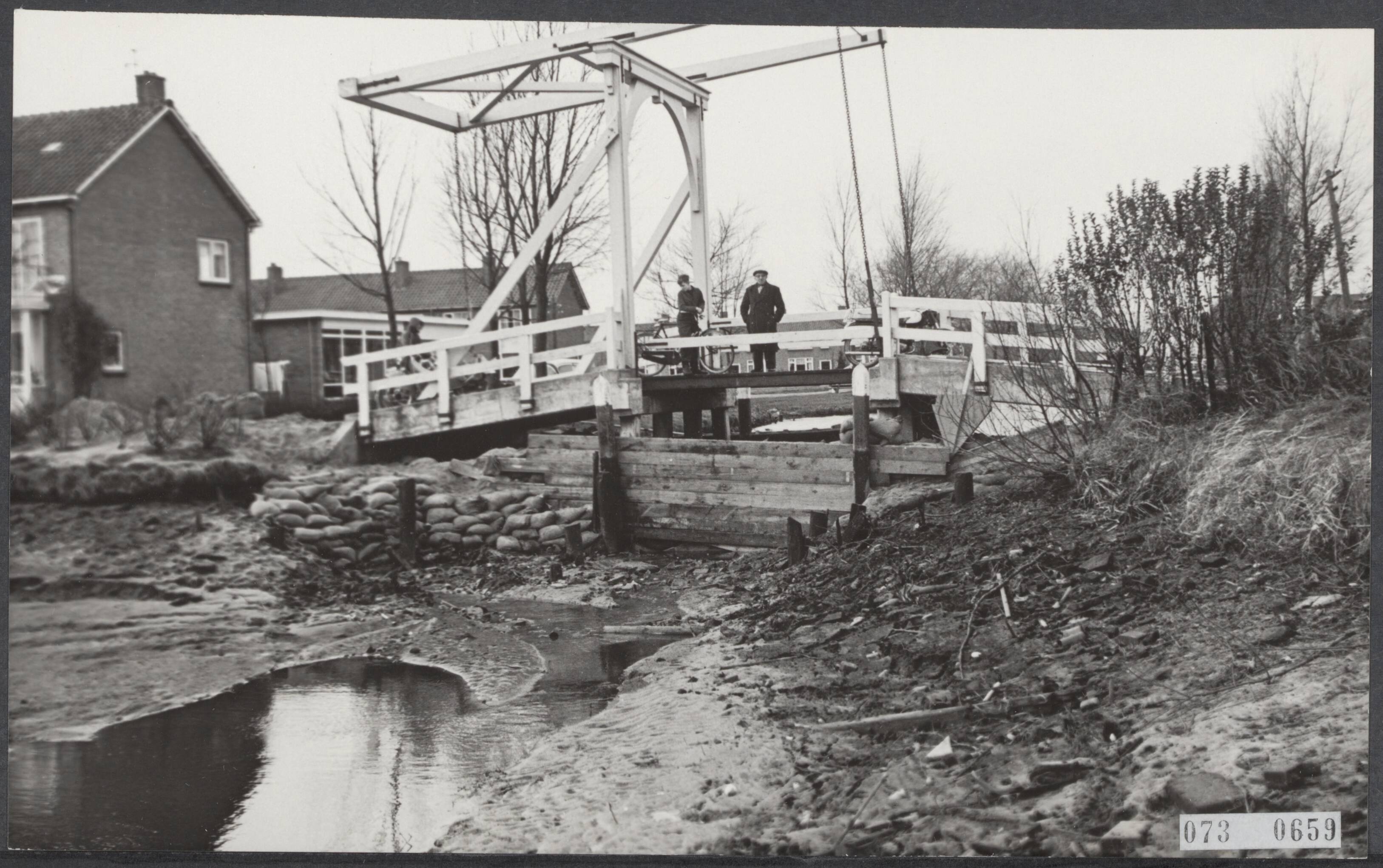 Fotocollectie Elsevier Binnenland — Bij Hazerswoude is bij werkzaamheden een polderdijk doorgebroken. Hierdoor stroomde water uit de boezem de weilanden in. Met houten schotten en zandzakken probeerd men sloten af te dammen — Foto: Koch, Eric / Anefo. Licentie: Set B: Rechtenvrij / Publiek Domein. Bron: Nationaal Archief. http://hdl.handle.net/10648/ae154684-d0b4-102d-bcf8-003048976d84