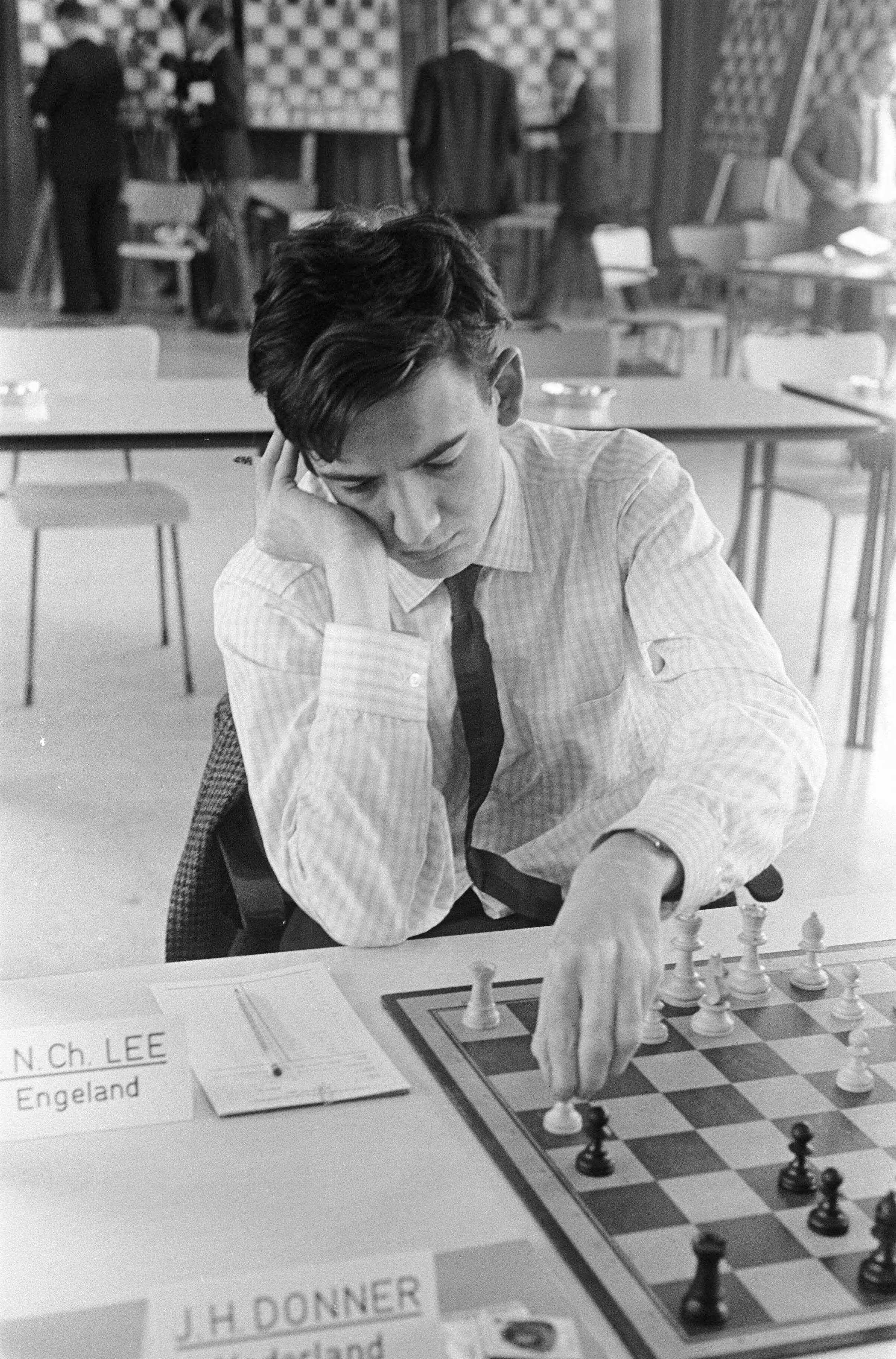 Fédération Internationale des Échecs (FIDE) -Zone schaaktoernooi 1966 in de kantine van 'De Nederlanden van 1845' te Den Haag — Lee aan het schaakbord — Foto: Fotograaf Onbekend / Anefo. Licentie: Set B: Rechtenvrij / Publiek Domein. Bron: Nationaal Archief. http://hdl.handle.net/10648/aafc6234-d0b4-102d-bcf8-003048976d84