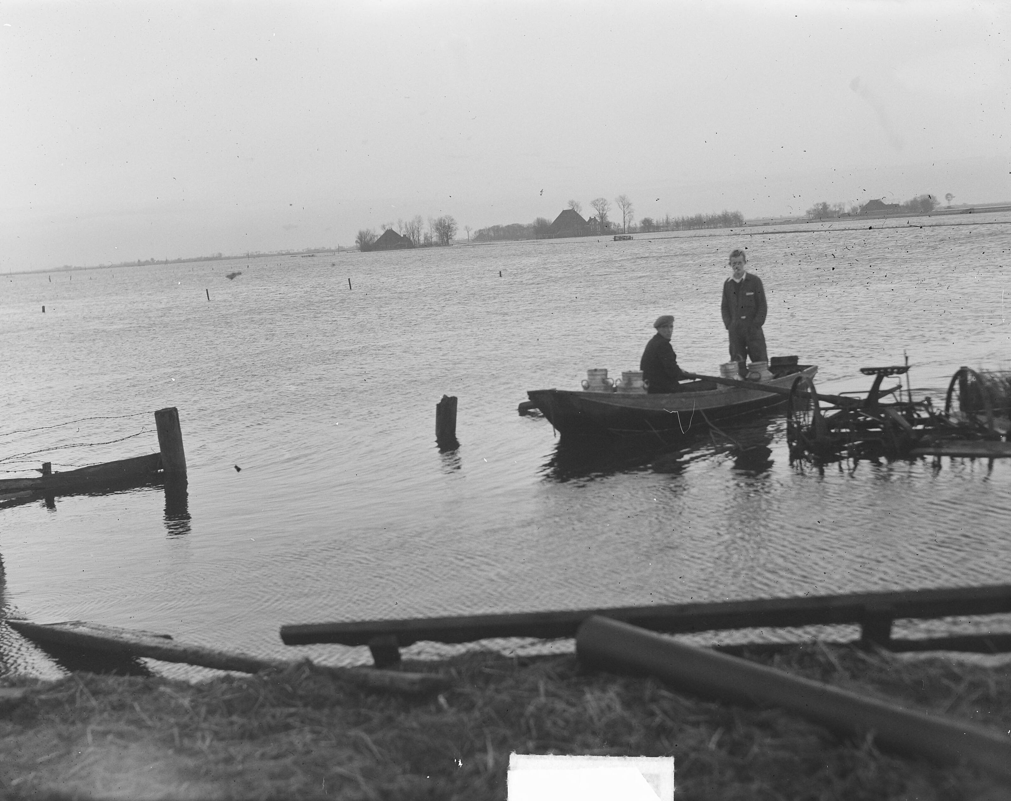 Hoogwater in Hempens (Friesland) — Hoog water in Friesland. Melkboer per vlot te Hempens — Foto: Oorschot, […] van / Anefo. Licentie: Set B: Rechtenvrij / Publiek Domein. Bron: Nationaal Archief. http://hdl.handle.net/10648/a8e50b0e-d0b4-102d-bcf8-003048976d84