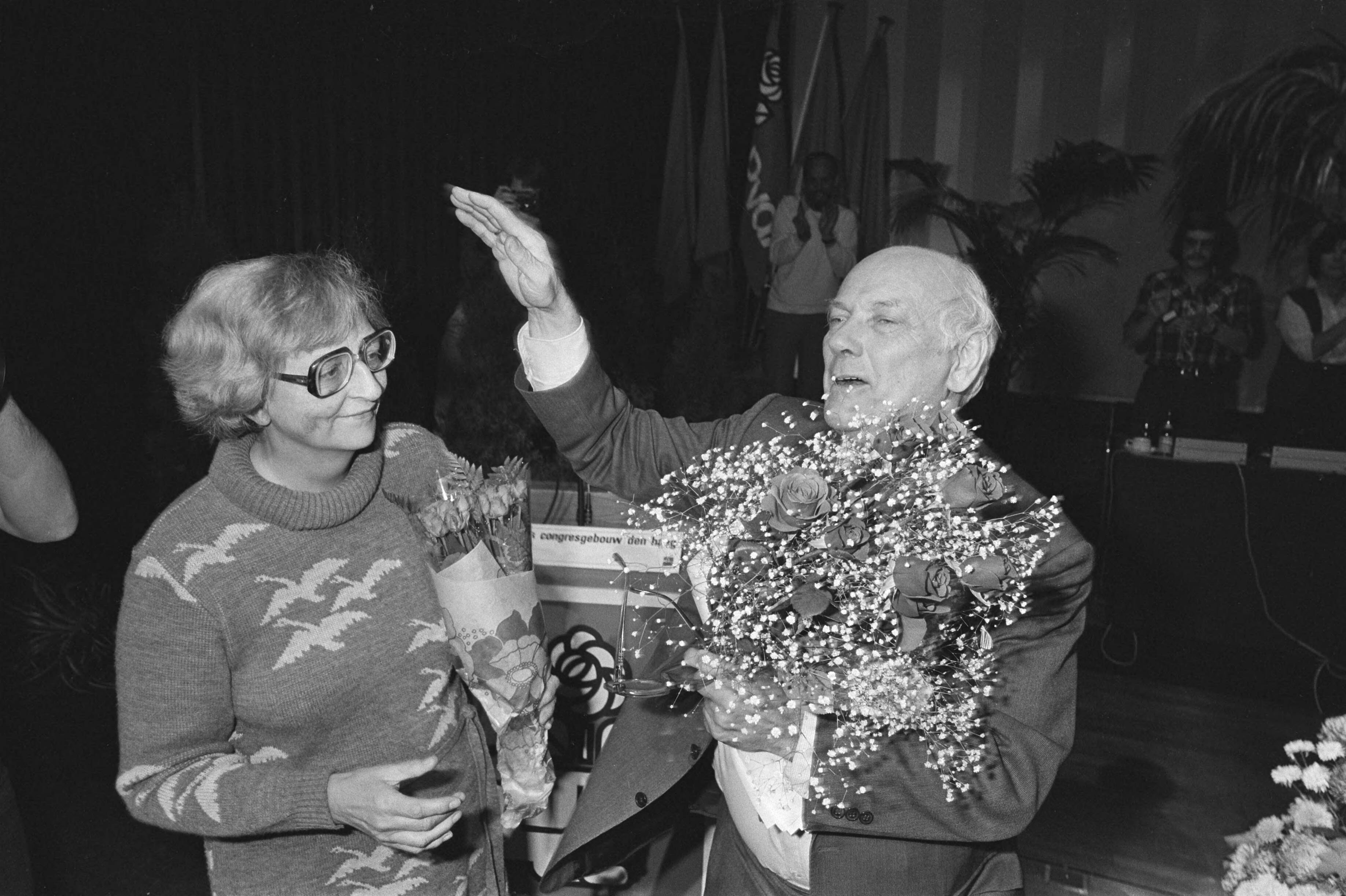 PvdA-congres in Den Haag besloten — Den Uyl met vrouw en bloemen tijdens de ovatie — Foto: Croes, Rob C. / Anefo. Licentie: Set B: Rechtenvrij / Publiek Domein. Bron: Nationaal Archief. http://hdl.handle.net/10648/ad0722b2-d0b4-102d-bcf8-003048976d84