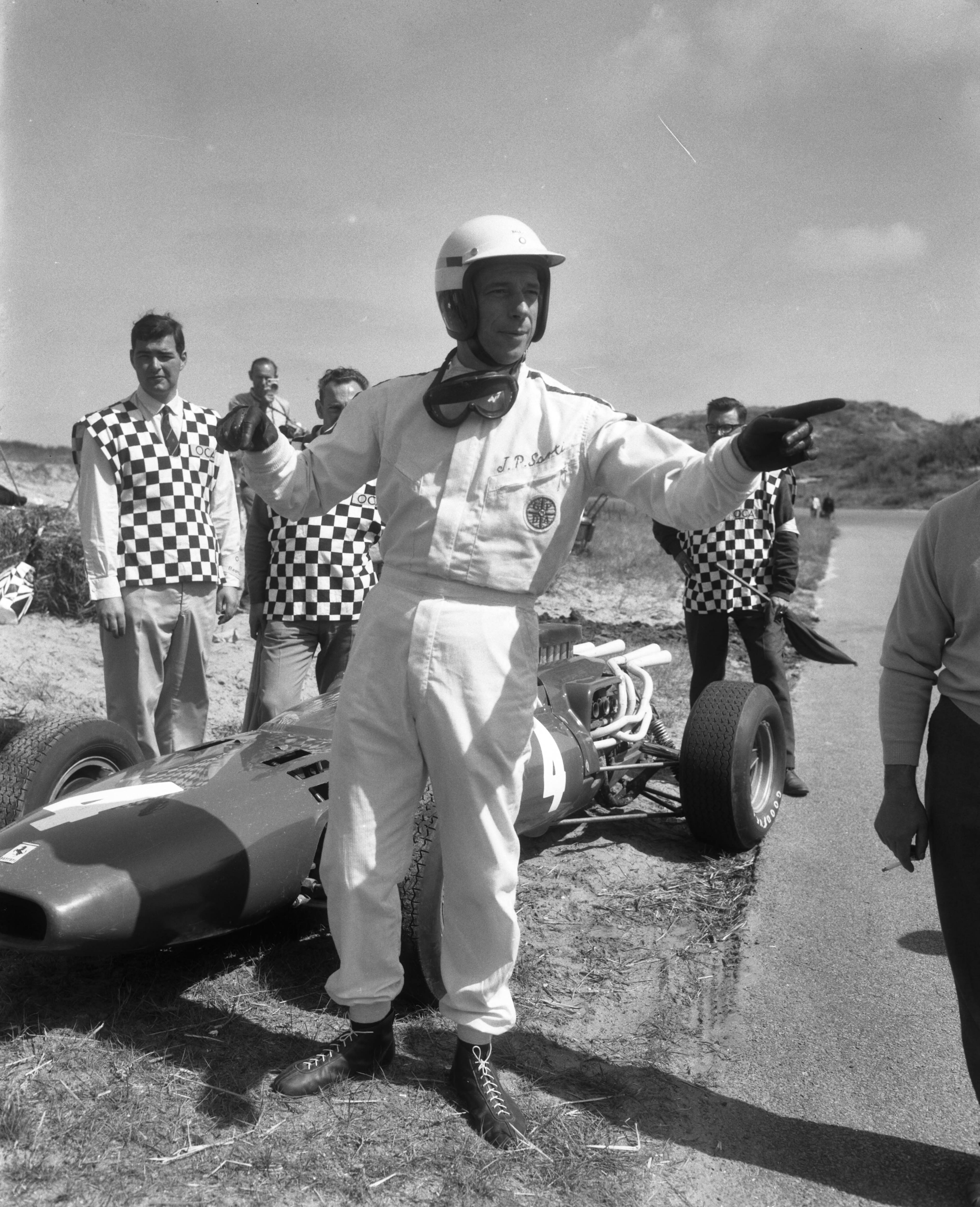 Fotocollectie Anefo — Cineramafilm "Grand Prix", filmopnames op het circuit van Zandvoort, Yves Montand [als coureur Jean-Pierre Sarti] bij zijn Ferrari — Foto: Bilsen, Joop van / Anefo. Licentie: Set B: Rechtenvrij / Publiek Domein. Bron: Nationaal Archief. http://hdl.handle.net/10648/aaf3c37c-d0b4-102d-bcf8-003048976d84