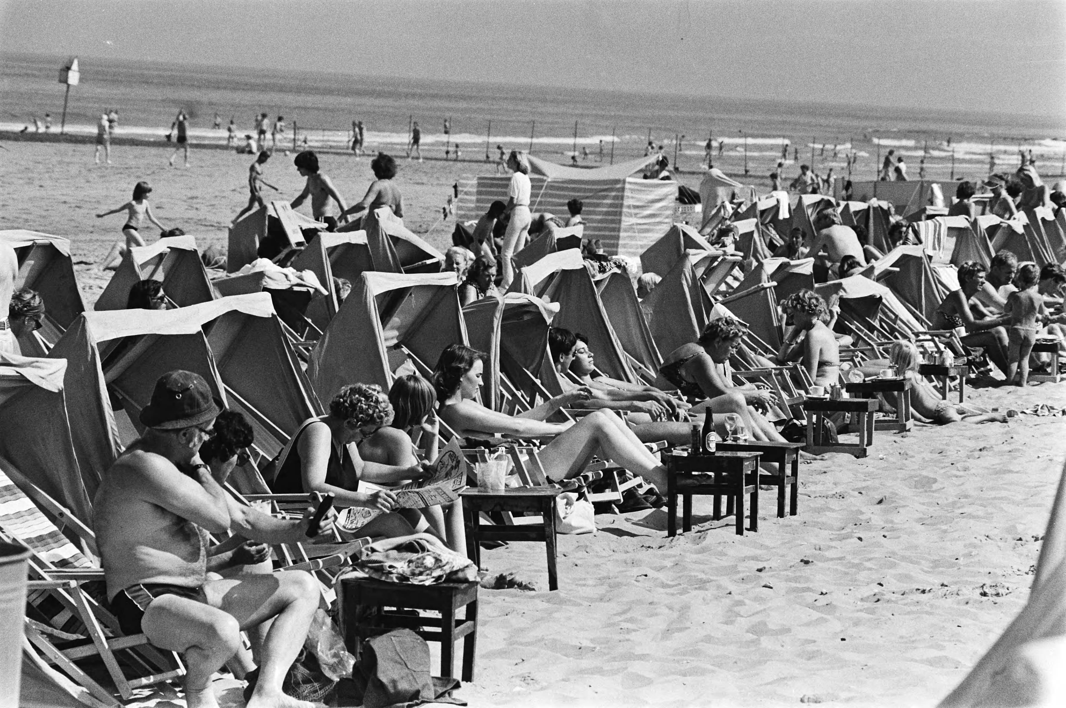 Fotocollectie Anefo — Eindelijk zomer, zonnende mensen op het strand in Scheveningen — Foto: Suyk, Koen / Anefo (1). Licentie: Set B: Rechtenvrij / Publiek Domein. Bron: Nationaal Archief. http://hdl.handle.net/10648/acce5ef0-d0b4-102d-bcf8-003048976d84