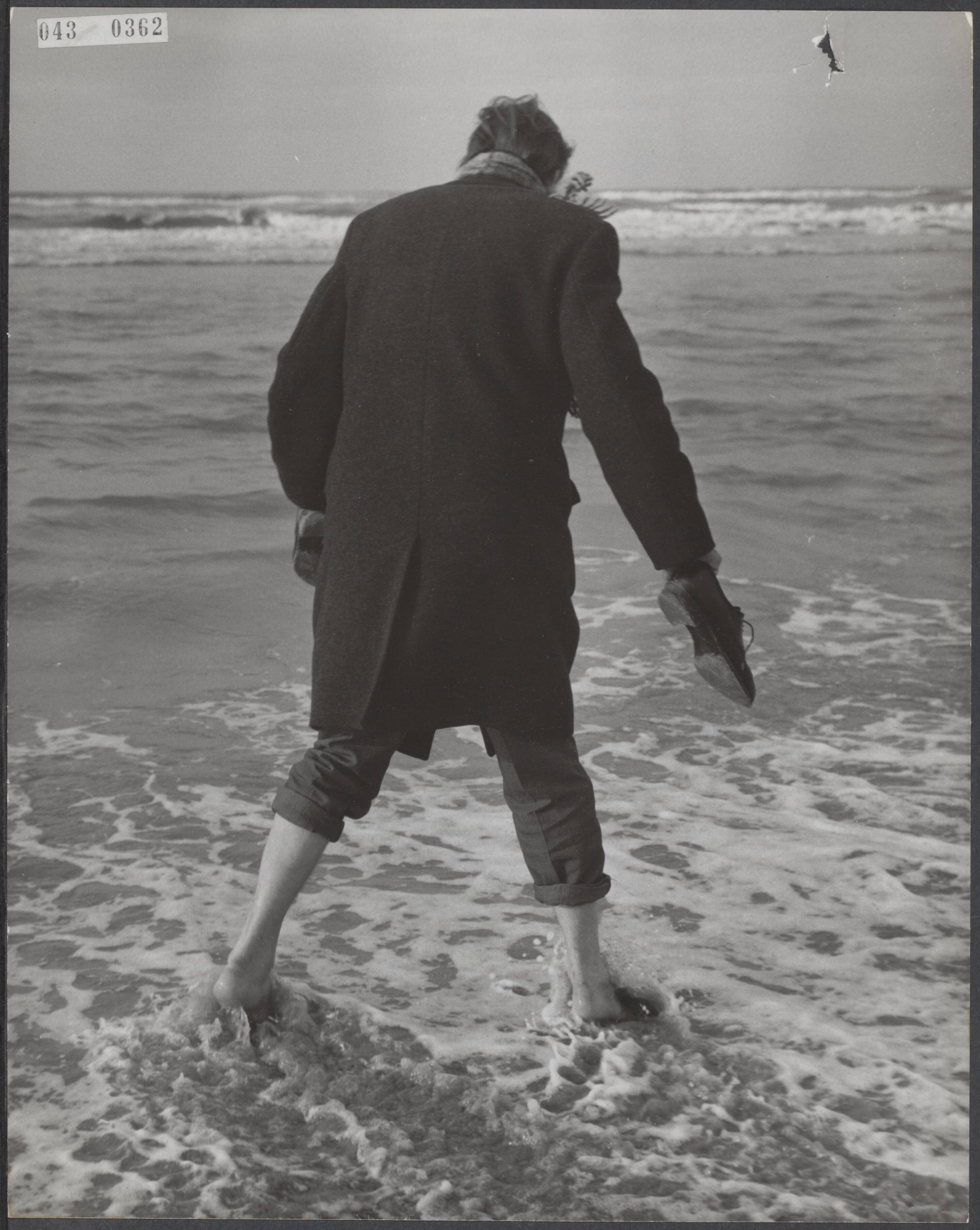 Fotocollectie Elsevier Binnenland — Eerste badgast met schoenen in de hand en gekleed in dikke jas op het srand van Zandvoort — Foto: Nijs, Jac. de / Anefo. Licentie: Set B: Rechtenvrij / Publiek Domein. Bron: Nationaal Archief. http://hdl.handle.net/10648/adf8c716-d0b4-102d-bcf8-003048976d84