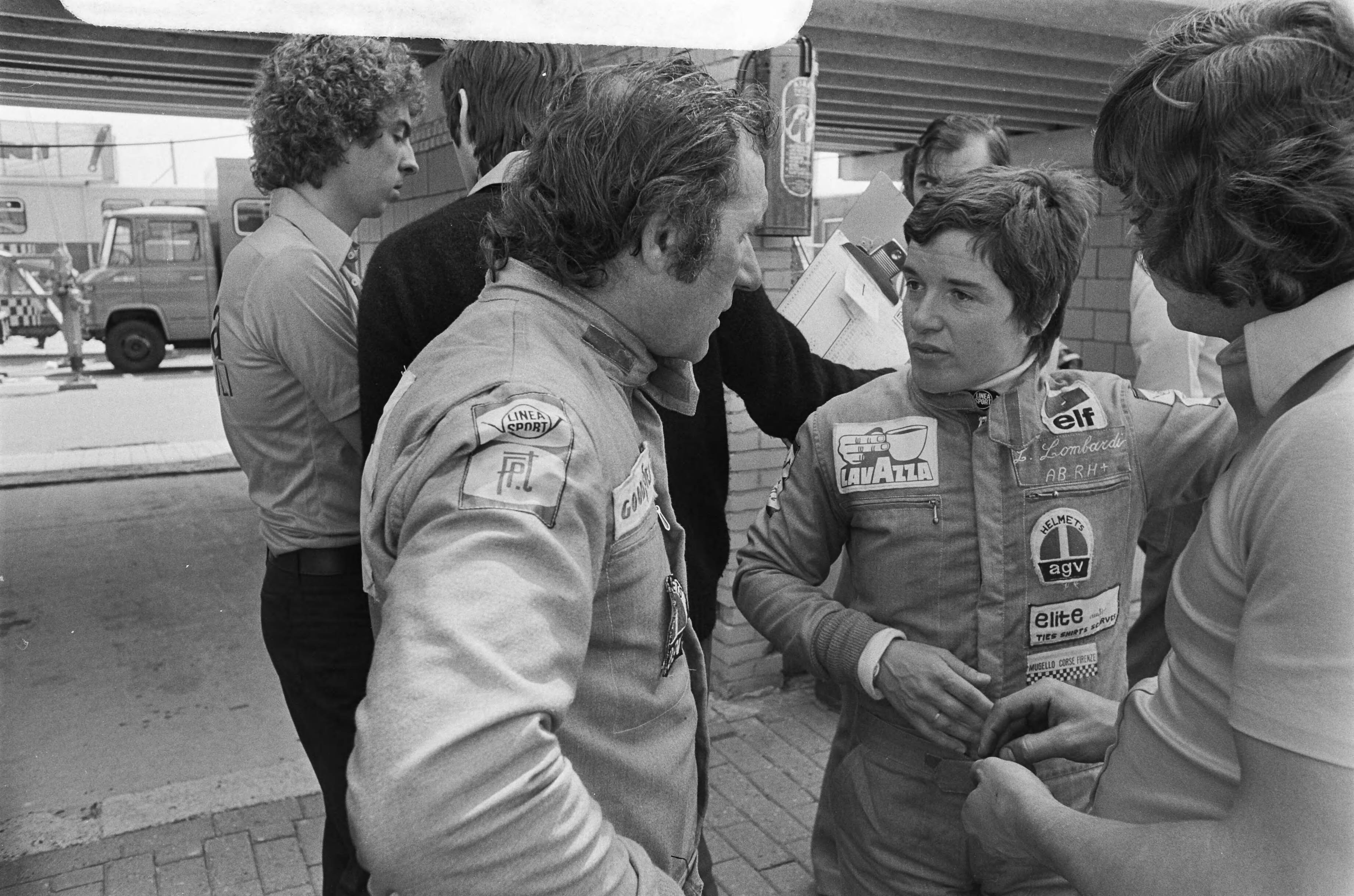 Training voor de Grand Prix op het circuit van Zandvoort — Lella Lombardi en Vittorio Brambilla in gesprek — Foto: Verhoeff, Bert / Anefo. Licentie: Set B: Rechtenvrij / Publiek Domein. Bron: Nationaal Archief. http://hdl.handle.net/10648/ac6bb8f4-d0b4-102d-bcf8-003048976d84