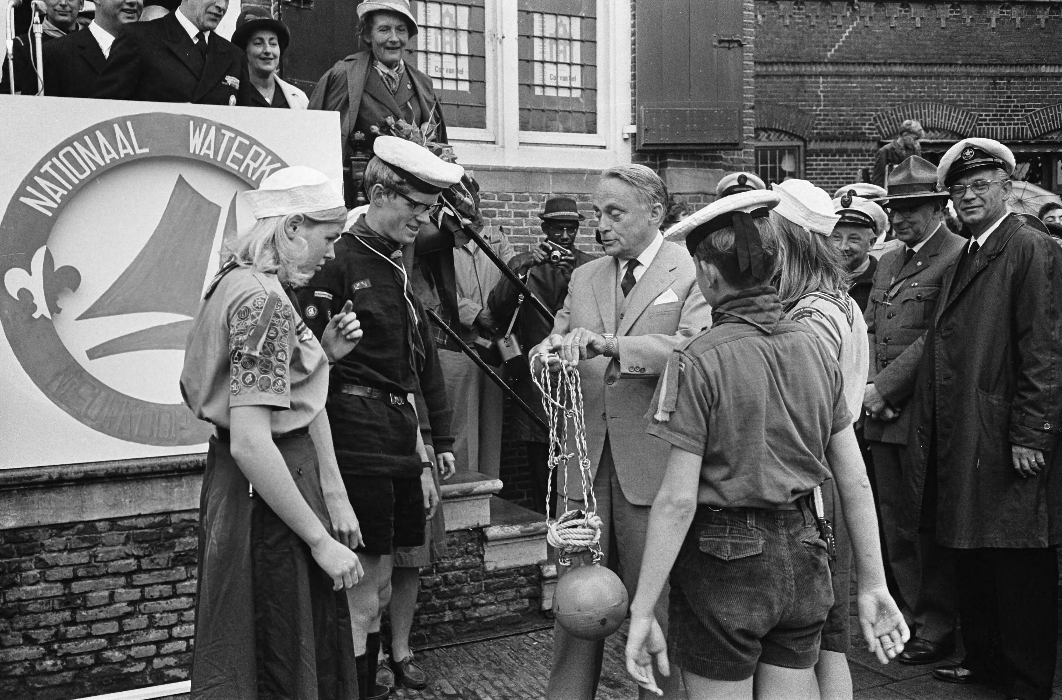 Fotocollectie Anefo — Nationaal Waterkamp in Nieuwkoop door de Commissaris van de Koningin in Zuid-Holland, mr. J. Klaasesz, geopend. Van zeeverkenners ontvangt hij een ankerboei — Foto: Koch, Eric / Anefo. Licentie: Set B: Rechtenvrij / Publiek Domein. Bron: Nationaal Archief. http://hdl.handle.net/10648/aab77f98-d0b4-102d-bcf8-003048976d84