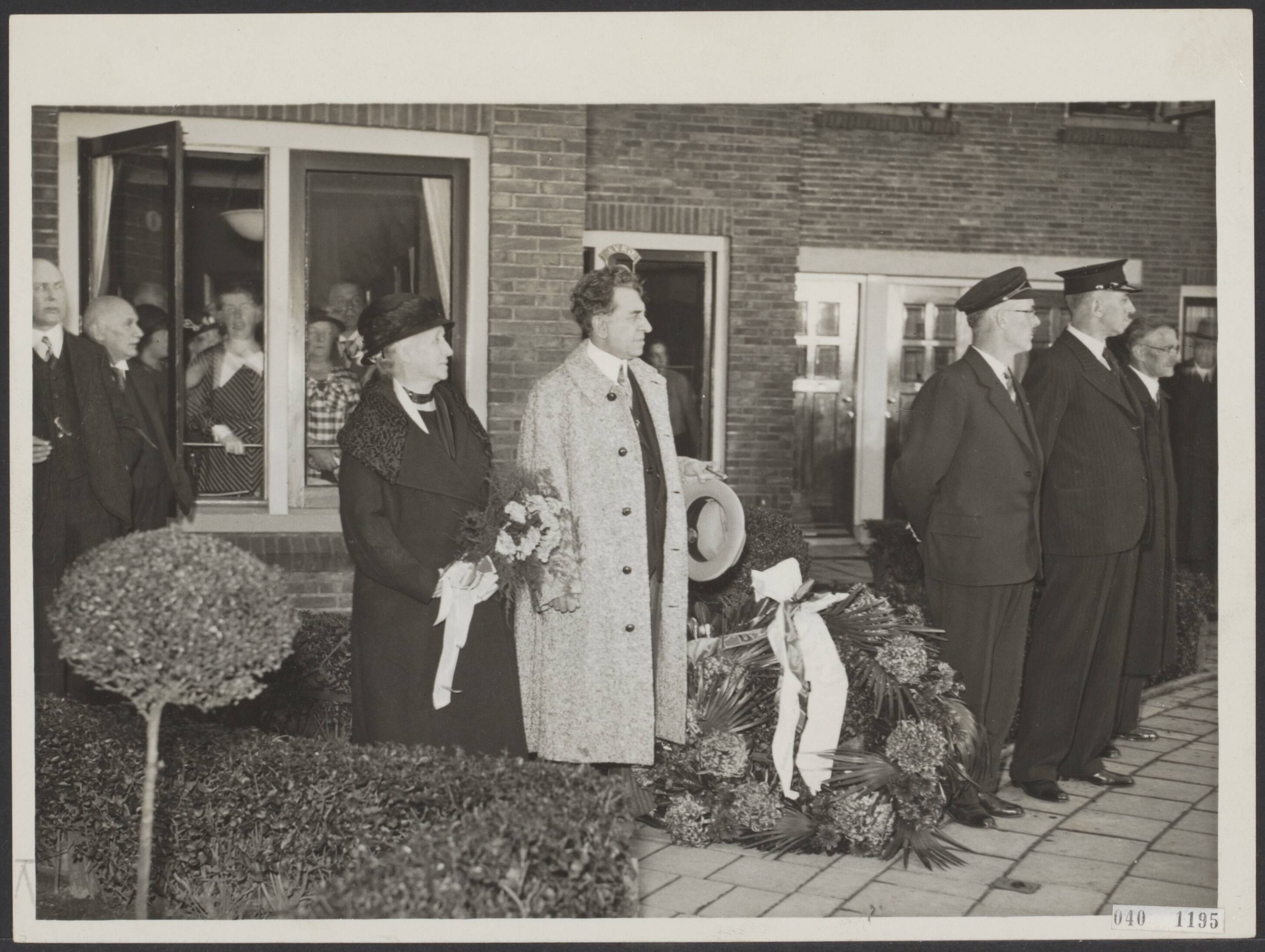 Fotocollectie Elsevier Binnenland — Ter gelegenheid van het feit dat de heer Kor Kuiler 25 jaar dirigent is van de Groningsche Orkest Vereeniging te Groningen, hebben hedenmiddag een tiental muziekkorpsen voor de heer Kuiler gedefileerd langs diens woning. Naast de heer Kuiler zijn echgenote — Foto: N.V. Polygoon. Licentie: Set B: Rechtenvrij / Publiek Domein. Bron: Nationaal Archief. http://hdl.handle.net/10648/adf55112-d0b4-102d-bcf8-003048976d84