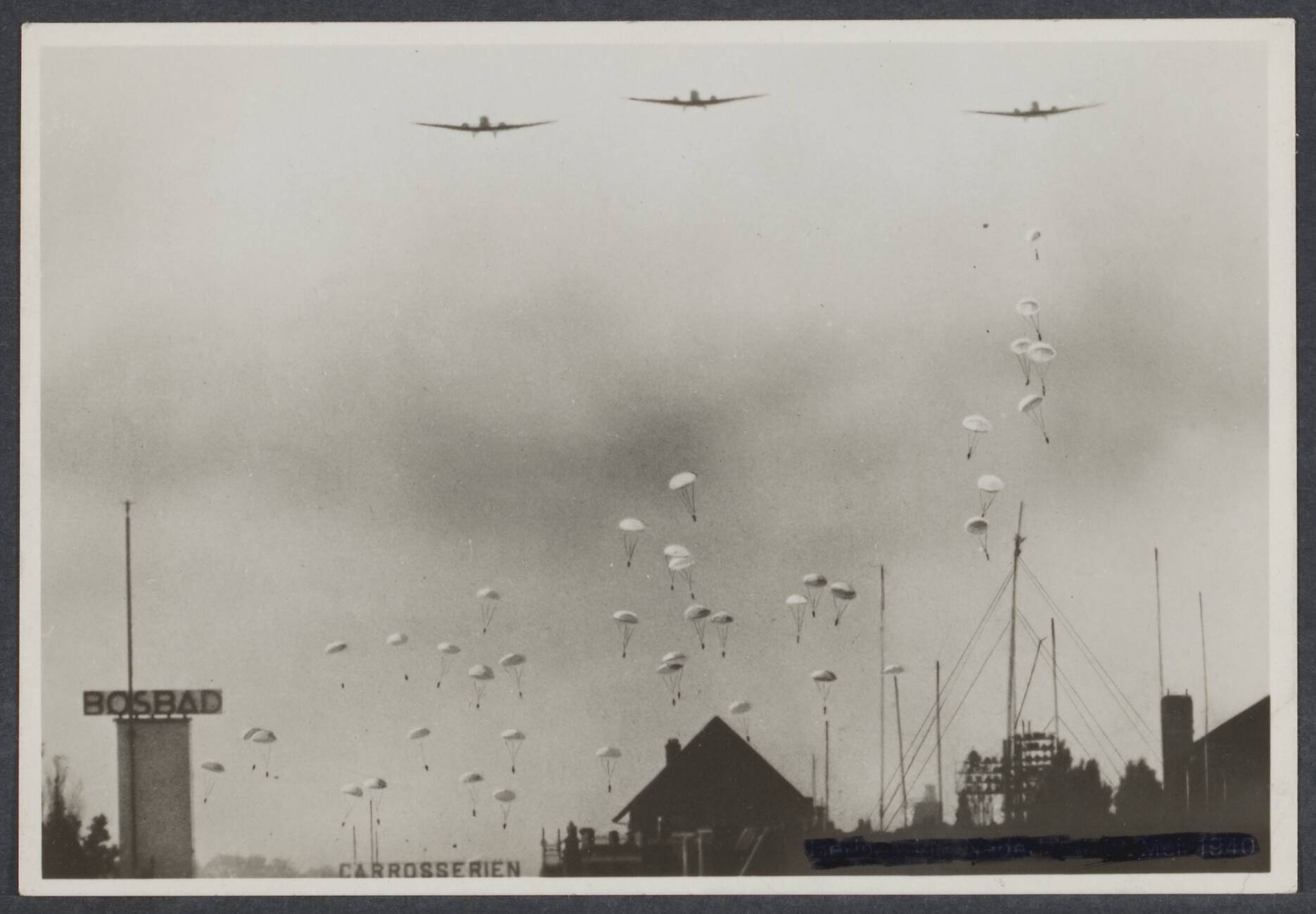 B. Nederlands Front - Meidagen '40. — Duitse parachutisten boven het Bezuidenhout te Den Haag — Foto: Onbekend / Publiek Domein of Rechtenvrij. Licentie: Set B: Rechtenvrij / Publiek Domein. Bron: Nationaal Archief. http://hdl.handle.net/10648/fe4fc4a6-2ab6-d7db-adba-8bad04b335c3