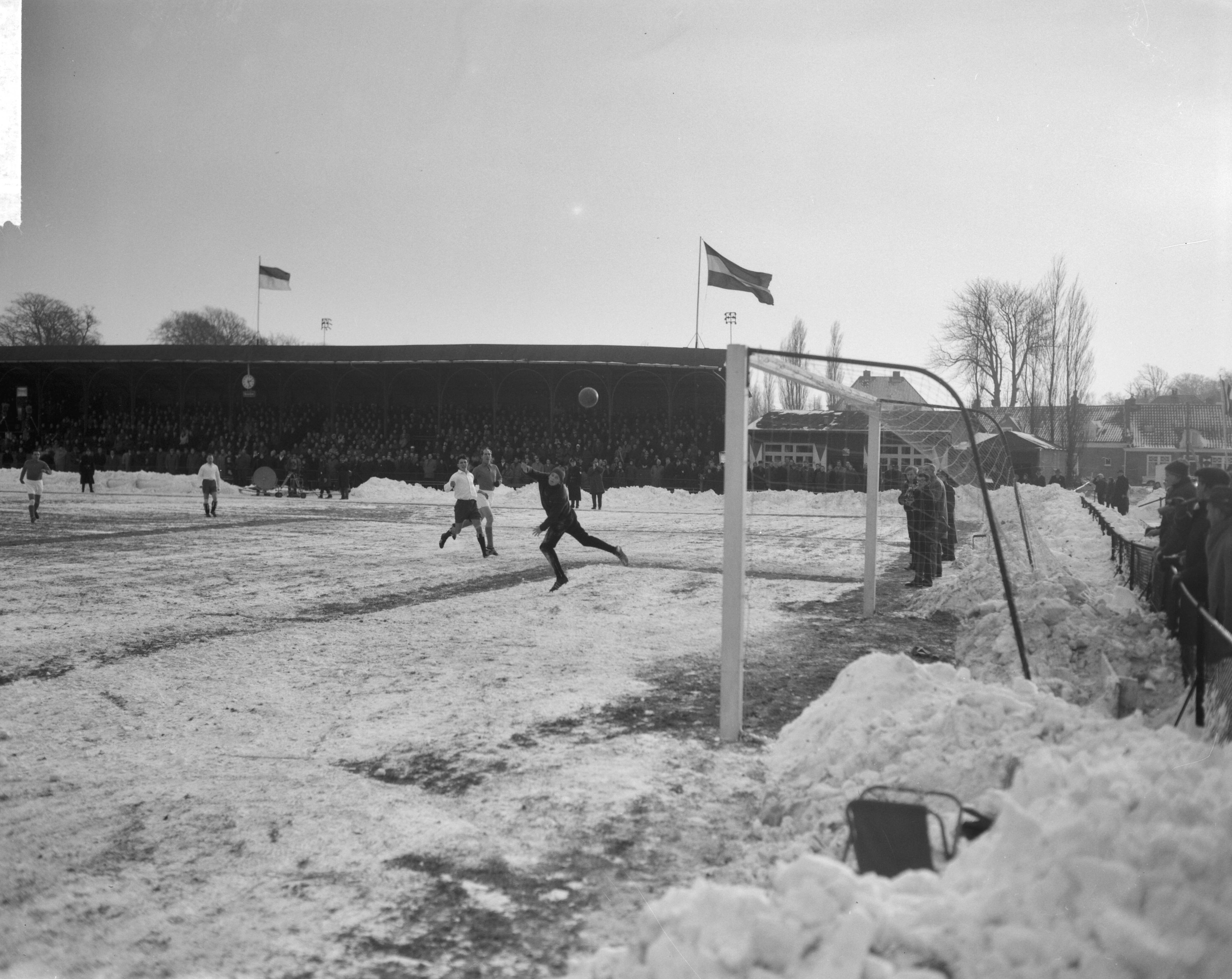 Fotocollectie Anefo — Traditionele nieuwjaars voetbalwedstrijd tussen de Koninklijke HFC en Oud-Internationals 2-8. Spelmoment voor het HFC doel. HFC-keeper Guus van der Meulen jr. ziet de bal voorbij vliegen. In de achtergrond Wout Heinen. Links Guus Dräger — Foto: Bilsen, Joop van / Anefo. Licentie: Set B: Rechtenvrij / Publiek Domein. Bron: Nationaal Archief. http://hdl.handle.net/10648/aa2466fe-d0b4-102d-bcf8-003048976d84