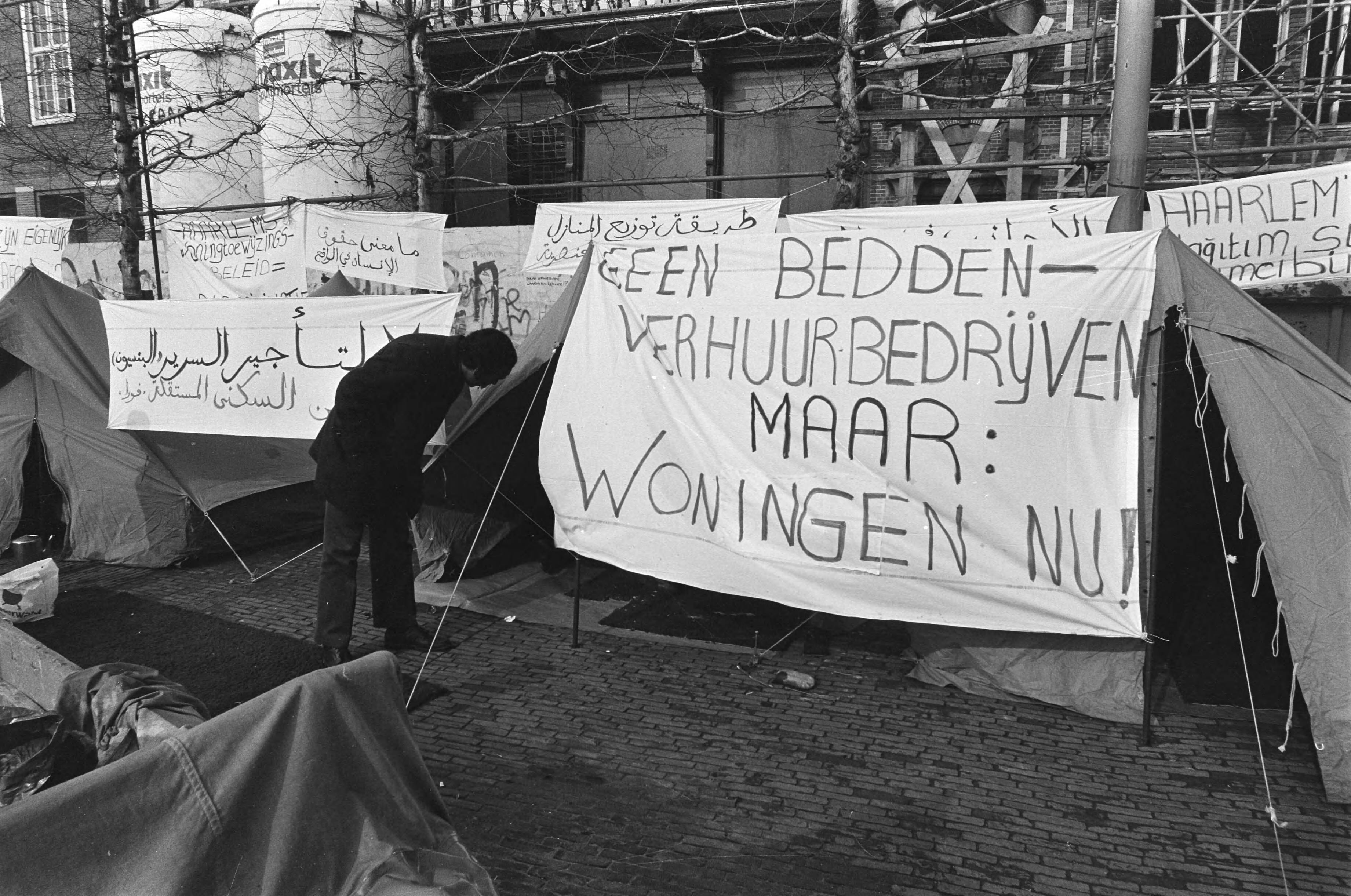 Fotocollectie Anefo — Tenten op Grote Markt in Haarlem neergezet door buitenlandse werknemers omdat ze nog steeds geen huis hebben van gemeente — Foto: Dijk, Hans van / Anefo. Licentie: Set B: Rechtenvrij / Publiek Domein. Bron: Nationaal Archief. http://hdl.handle.net/10648/acf5ccd8-d0b4-102d-bcf8-003048976d84