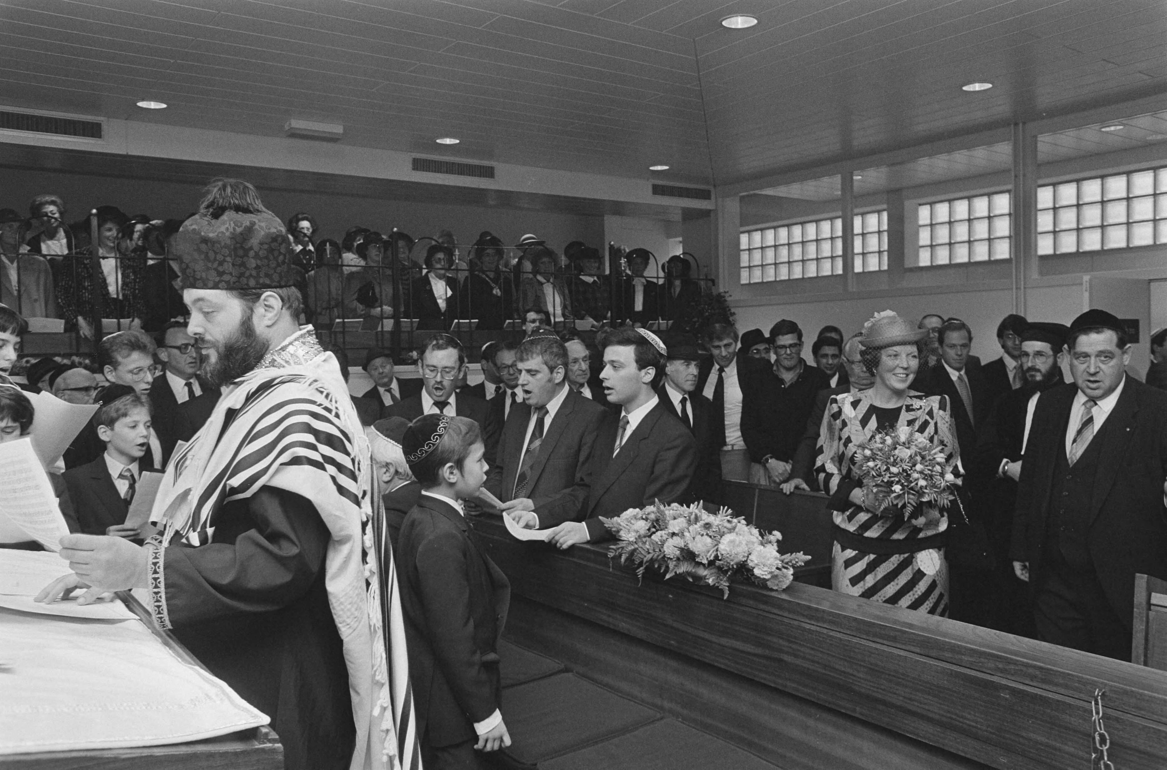 Fotocollectie Anefo — Koningin Beatrix bij inwijding nieuwe synagoge van Nederlands-Israëlitische gemeente in Den Haag ; links de voorzanger, rechts: Koningin Beatrix — Foto: Croes, Rob C. / Anefo. Licentie: Set B: Rechtenvrij / Publiek Domein. Bron: Nationaal Archief. http://hdl.handle.net/10648/ad5802d6-d0b4-102d-bcf8-003048976d84
