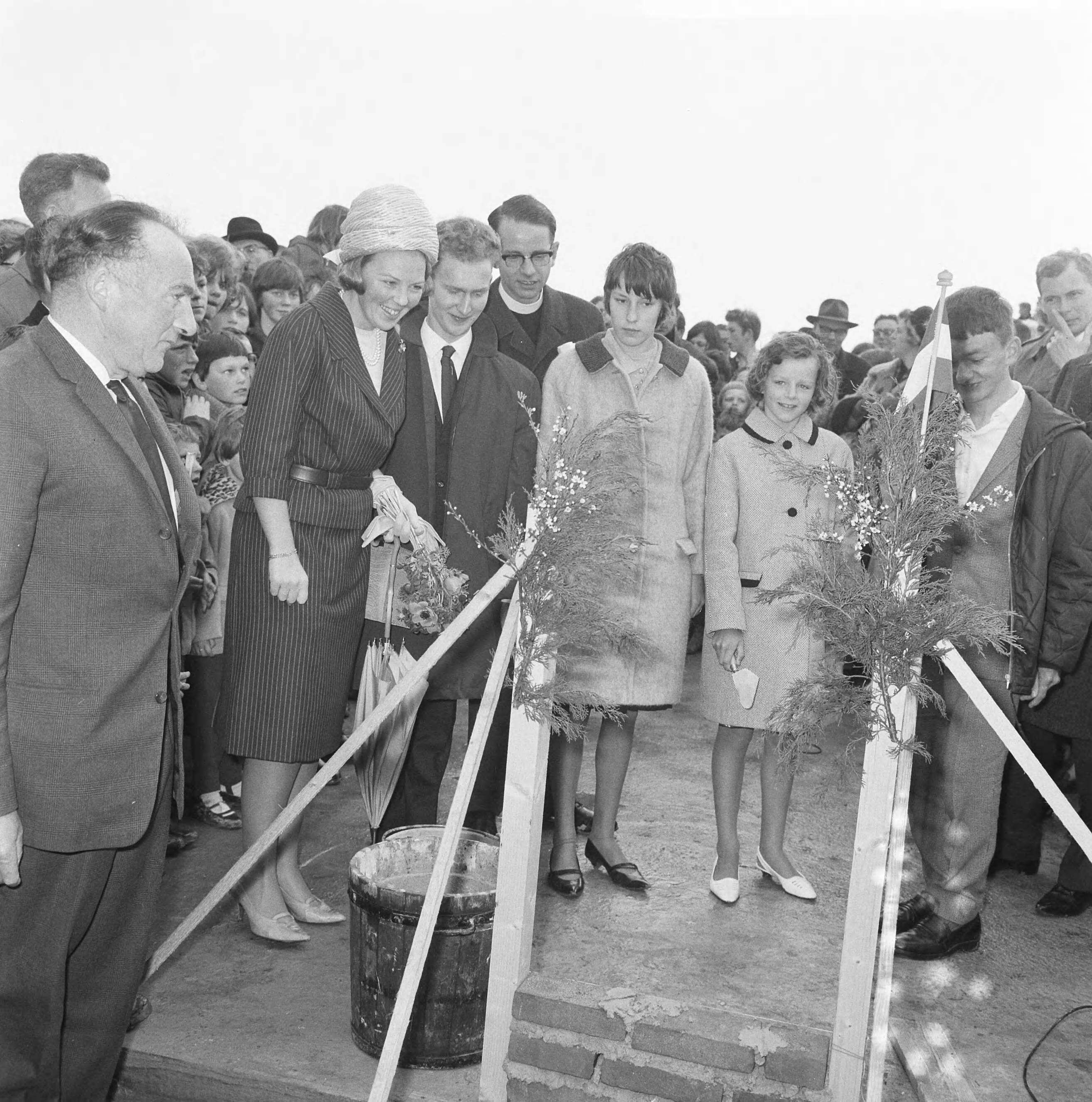 Fotocollectie Anefo — Prinses Beatrix was aanwezig bij de eerste steenlegging voor het jongerenontmoetingscentrum "Het Zilveren Schor" nabij Arnemuiden. De eerste stenen werden gemetseld door twee schoolmeisjes uit Arnemuiden, Janna Schets en Leuntje Schroevers, en twee jongens uit het zeehospitium in Oostkapelle, Dirk Albregtse en Wim Segeler, achter hen de voorzitter van de Stichting Zilveren Jeugdcentra, pater W.A.M. Alting von Geusau — Foto: Nijs, Jac. de / Anefo. Licentie: Set B: Rechtenvrij / Publiek Domein. Bron: Nationaal Archief. http://hdl.handle.net/10648/aaa1c20c-d0b4-102d-bcf8-003048976d84