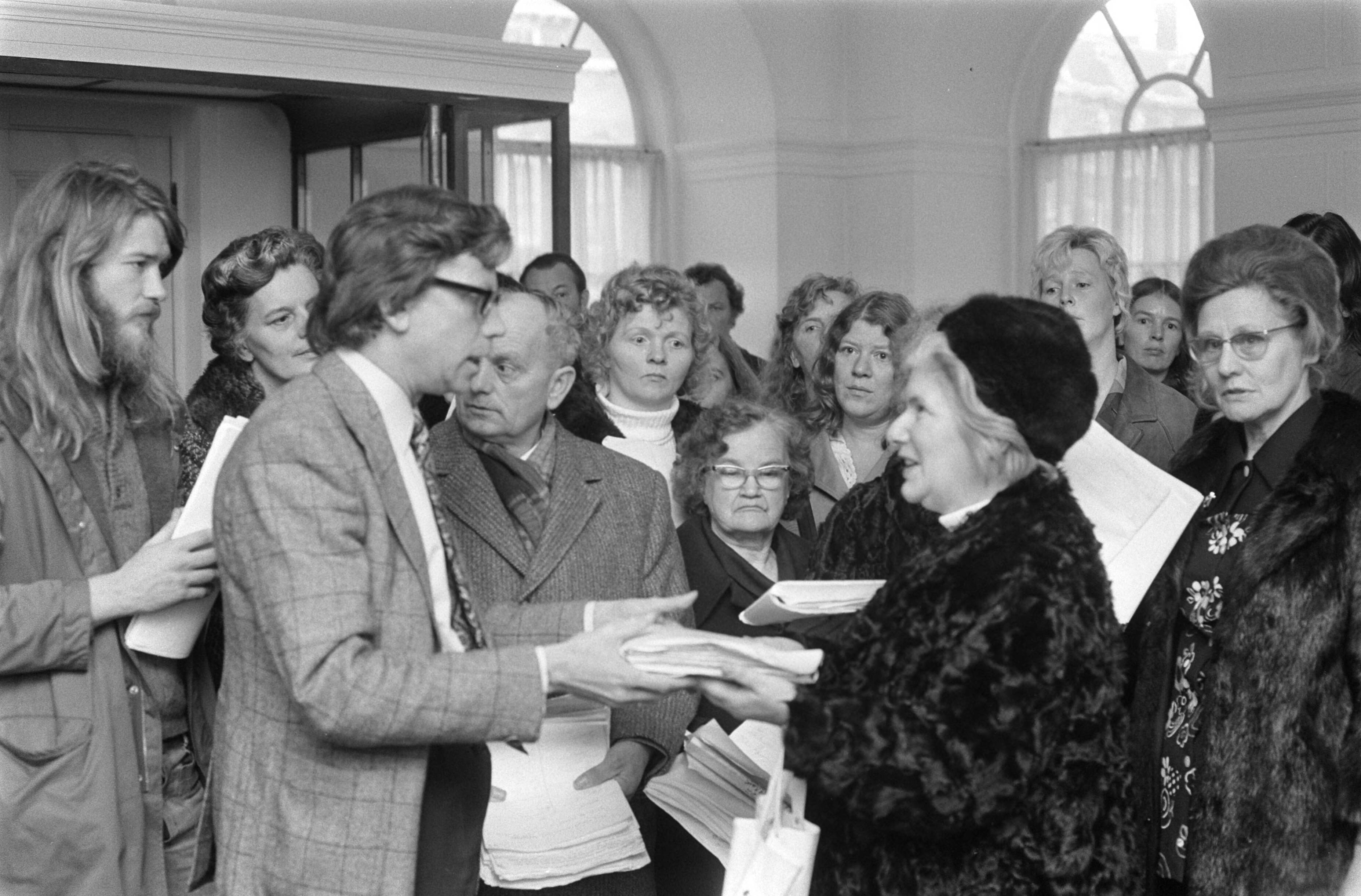 Huisvrouwen demonstreren tegen prijsverhogingen in Den Haag — De heer Wierenga, voorzitter van de Commissie Economische Zaken, neemt handtekeningen in ontvangst — Foto: Fotograaf Onbekend / Anefo. Licentie: Set B: Rechtenvrij / Publiek Domein. Bron: Nationaal Archief. http://hdl.handle.net/10648/ac41dbce-d0b4-102d-bcf8-003048976d84