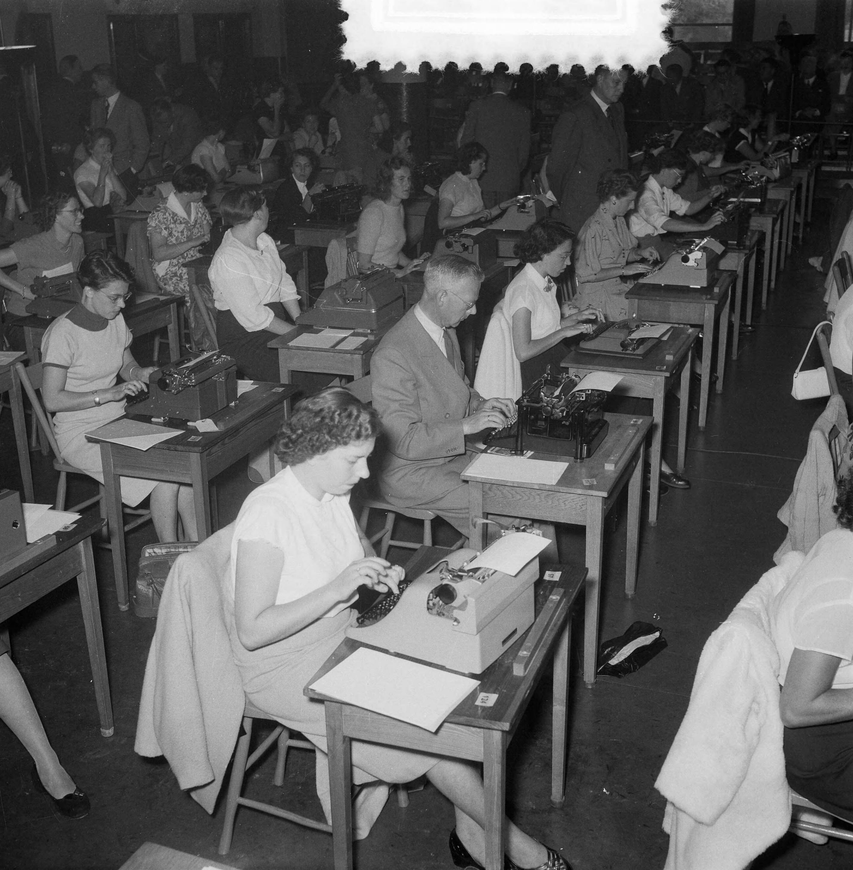 Fotocollectie Anefo — Nationaal Kampioenschap Machineschrijven in de Houtrusthallen te Den Haag. Deelnemende typistes, waaronder ook een mannelijke deelnemer — Foto: Noske, J.D. / Anefo. Licentie: Set B: Rechtenvrij / Publiek Domein. Bron: Nationaal Archief. http://hdl.handle.net/10648/a9138c4a-d0b4-102d-bcf8-003048976d84