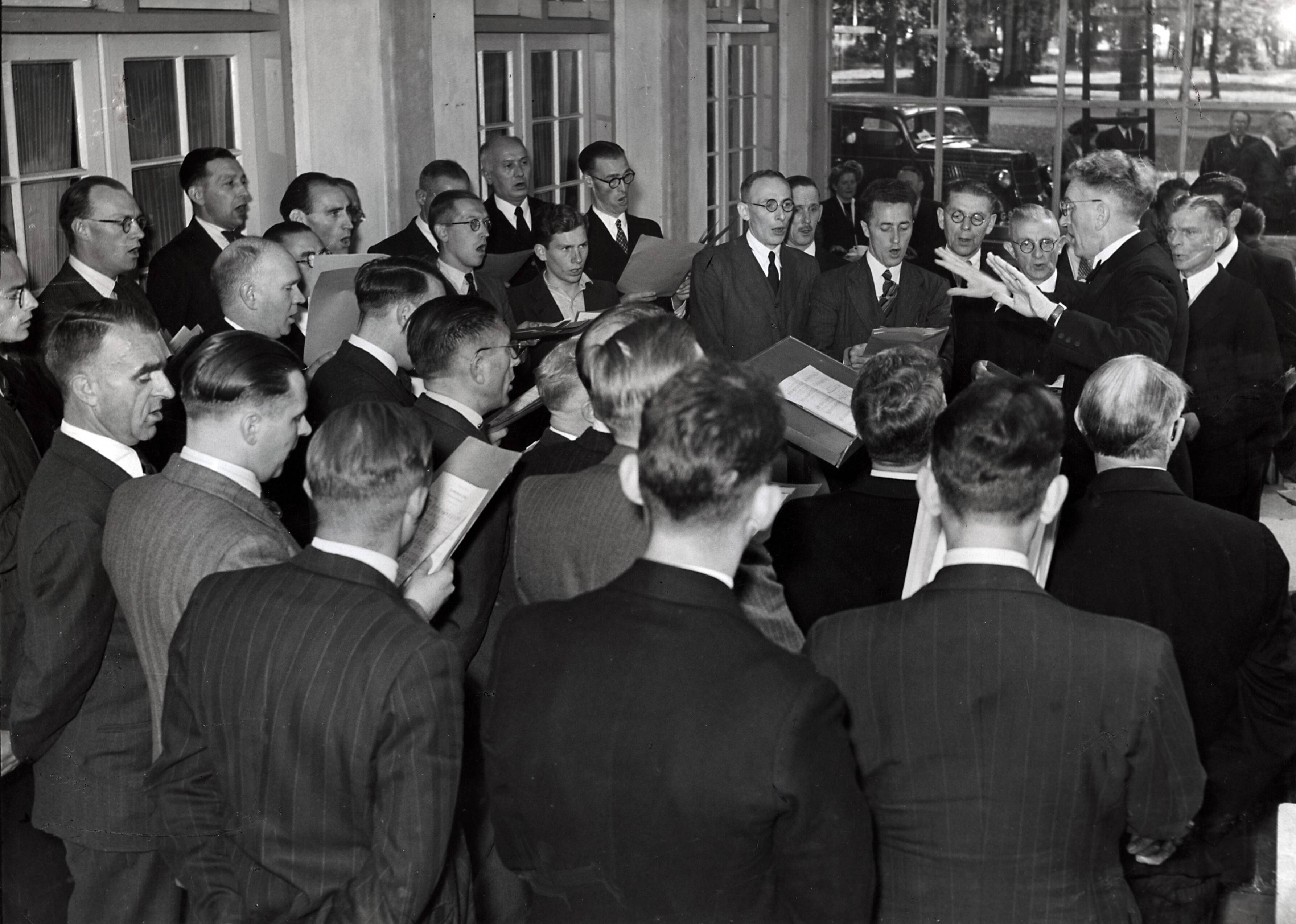 Drukkerij Spaarnestad — [40-jarig jubileum N.V. De Spaarnestad] [een mannenkoor zingt] — Foto: Fotograaf Onbekend / Fotobureau onbekend / Spaarnestad Photo (05887). Licentie: Set B: Rechtenvrij / Publiek Domein. Bron: Nationaal Archief. http://hdl.handle.net/10648/35429da6-39fc-a382-e063-6df0900a6686