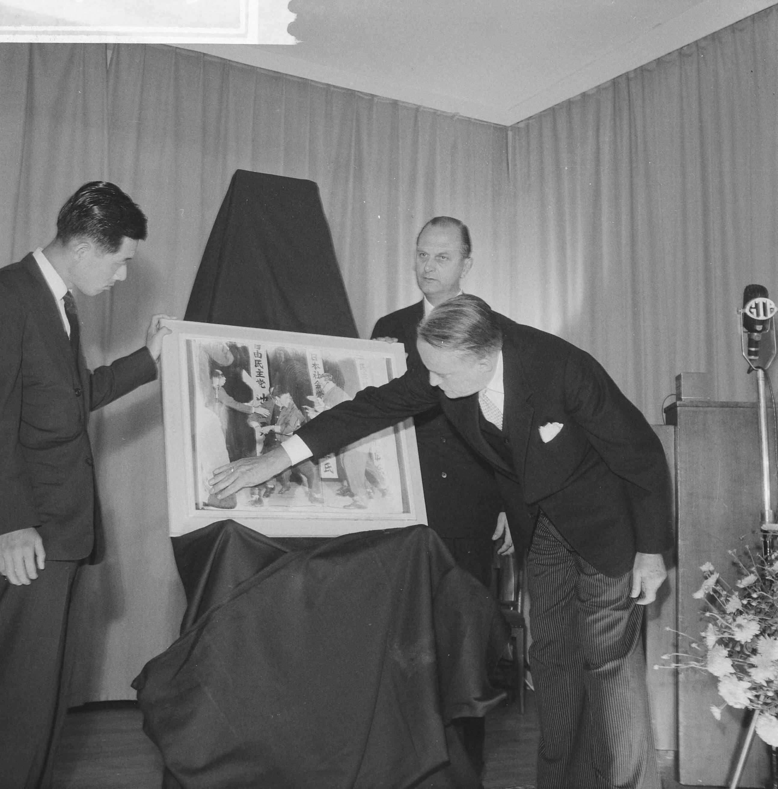 Fotocollectie Anefo — Opening World Press Photo 1961. Commissaris der Koningin in Zuid-Holland, mr. J. Klaasesz en de Japanse fotograaf Yasushi Nagao, winnaar van de World Press Photo 1961. In het midden voorzitter Peter van Breukelen — Foto: Nijs, Jac. de / Anefo. Licentie: Set B: Rechtenvrij / Publiek Domein. Bron: Nationaal Archief. http://hdl.handle.net/10648/a9e4e93e-d0b4-102d-bcf8-003048976d84