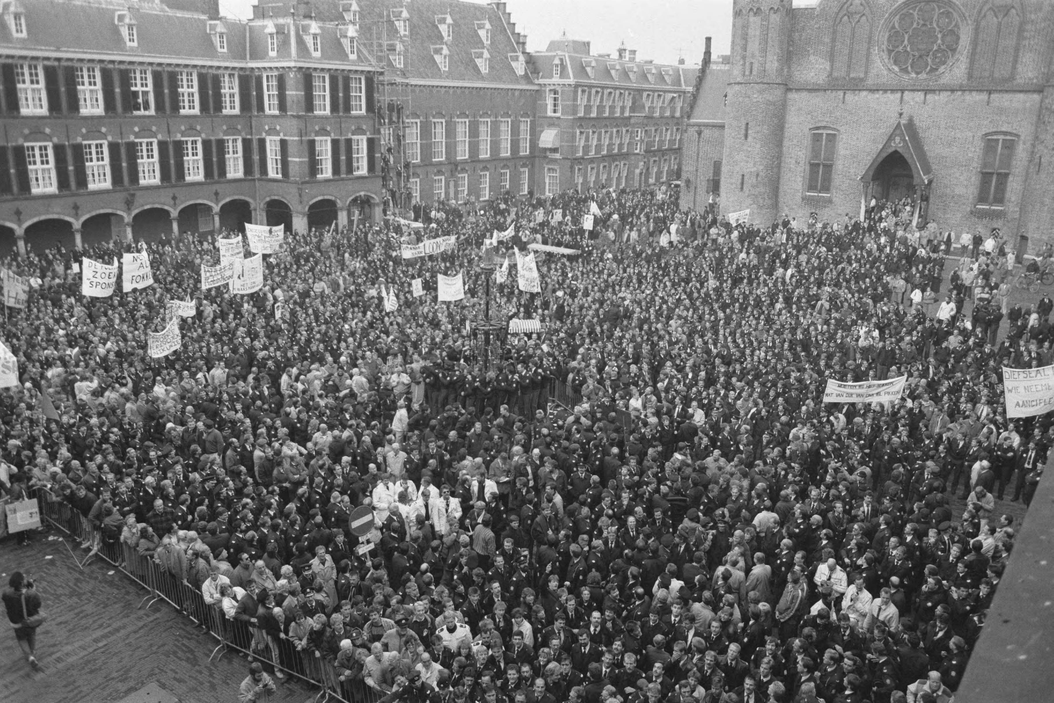 Fotocollectie Anefo — Politie demonstreert in Den Haag tegen bezuinigingen; geheel gevuld Binnenhof — Foto: Croes, Rob C. / Anefo. Licentie: Set B: Rechtenvrij / Publiek Domein. Bron: Nationaal Archief. http://hdl.handle.net/10648/ad657196-d0b4-102d-bcf8-003048976d84