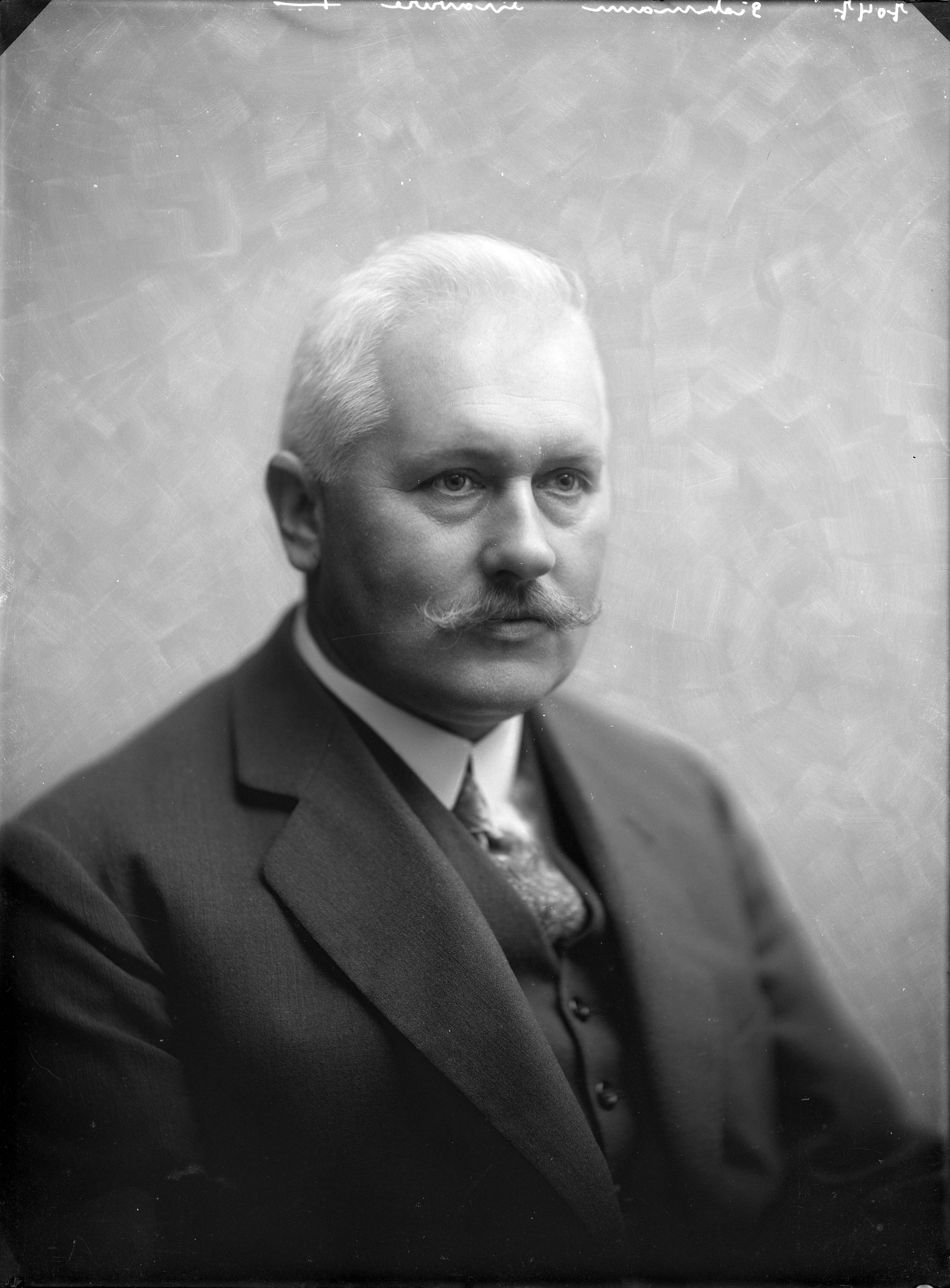 Portretten, "Lifestyle, gebruiken" — Studio opnames. Portret van een man met wit haar en snor in een driedelig pak. Haarlem, Nederland. 1918-1930. 7047 Sisterman gravure — Foto: Berg, Th.C.J. van den / Spaarnestad Photo (05887). Licentie: Set B: Rechtenvrij / Publiek Domein. Bron: Nationaal Archief. http://hdl.handle.net/10648/35429da7-c707-a382-e063-6df0900a6686