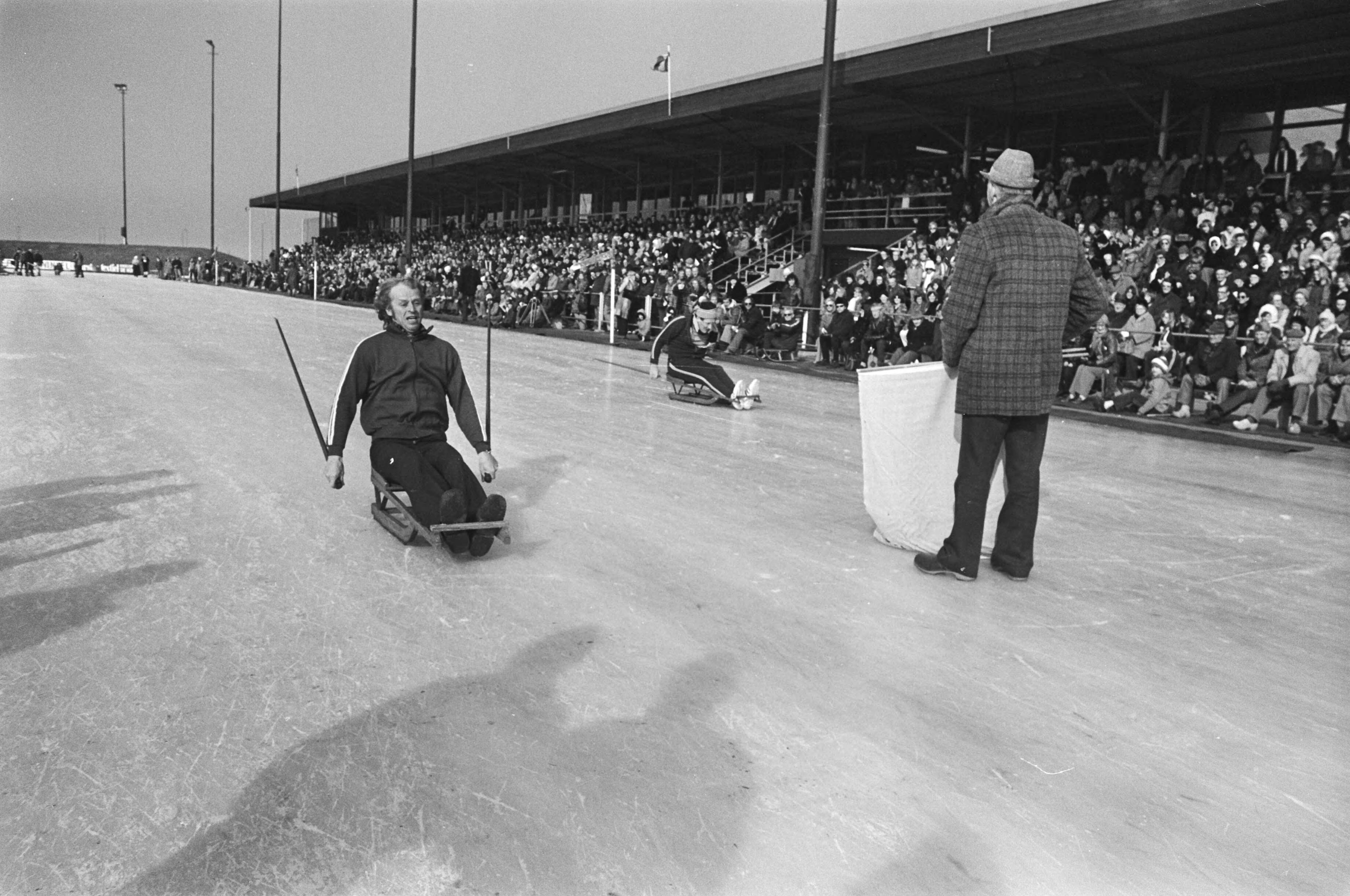 Fotocollectie Anefo — Oud-hollandse ijsfolklore op kunstijsbaan Alkmaar; priksleeen — Foto: Bogaerts, Rob / Anefo. Licentie: Set B: Rechtenvrij / Publiek Domein. Bron: Nationaal Archief. http://hdl.handle.net/10648/ac7eab30-d0b4-102d-bcf8-003048976d84