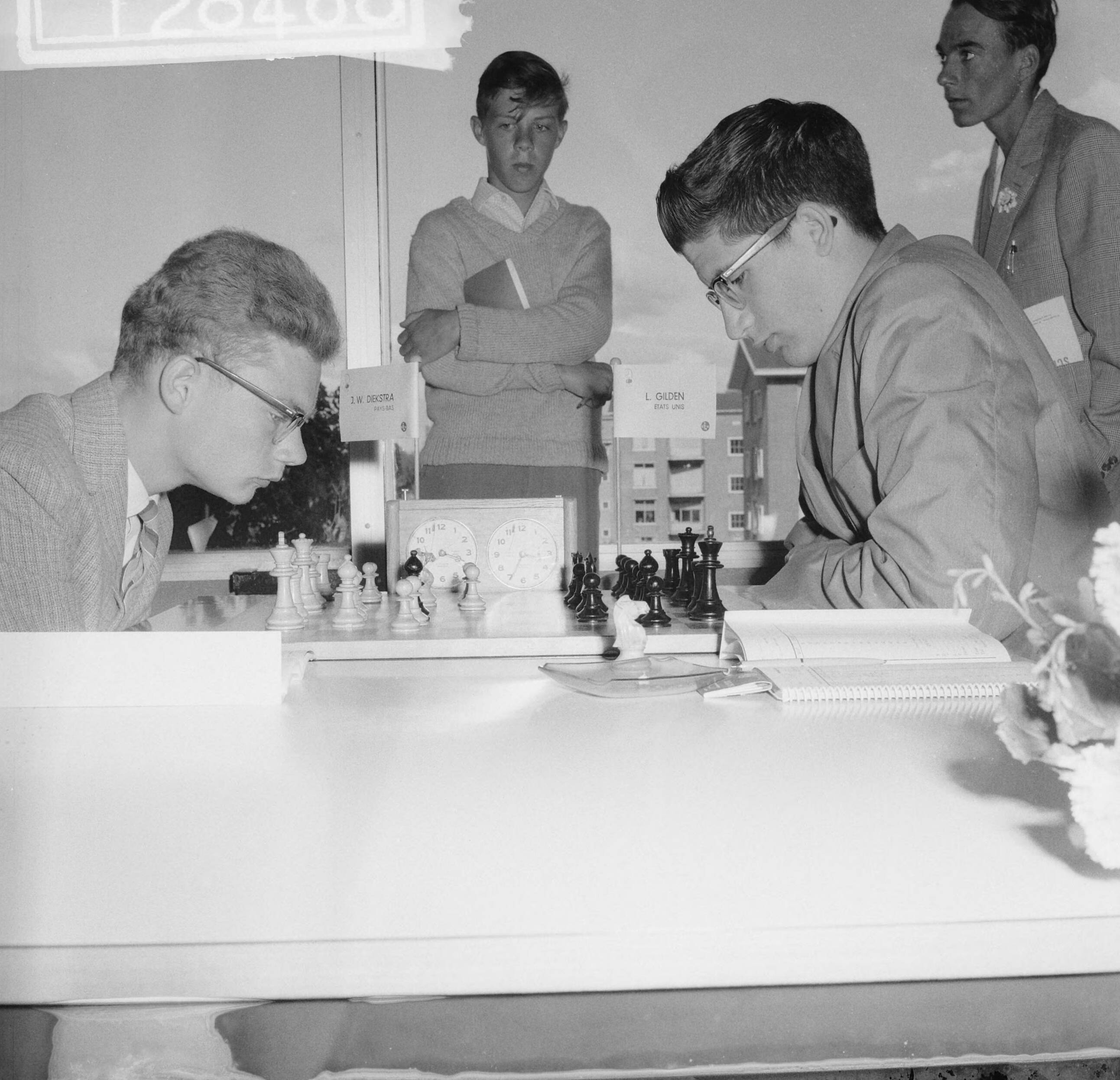 Fotocollectie Anefo — Jeugdwereldkampioenschap schaken te Den Haag. J.W. Diekstra en Lawrence Gilden (USA) — Foto: Lindeboom, Henk / Anefo. Licentie: Set B: Rechtenvrij / Publiek Domein. Bron: Nationaal Archief. http://hdl.handle.net/10648/a9dfd390-d0b4-102d-bcf8-003048976d84
