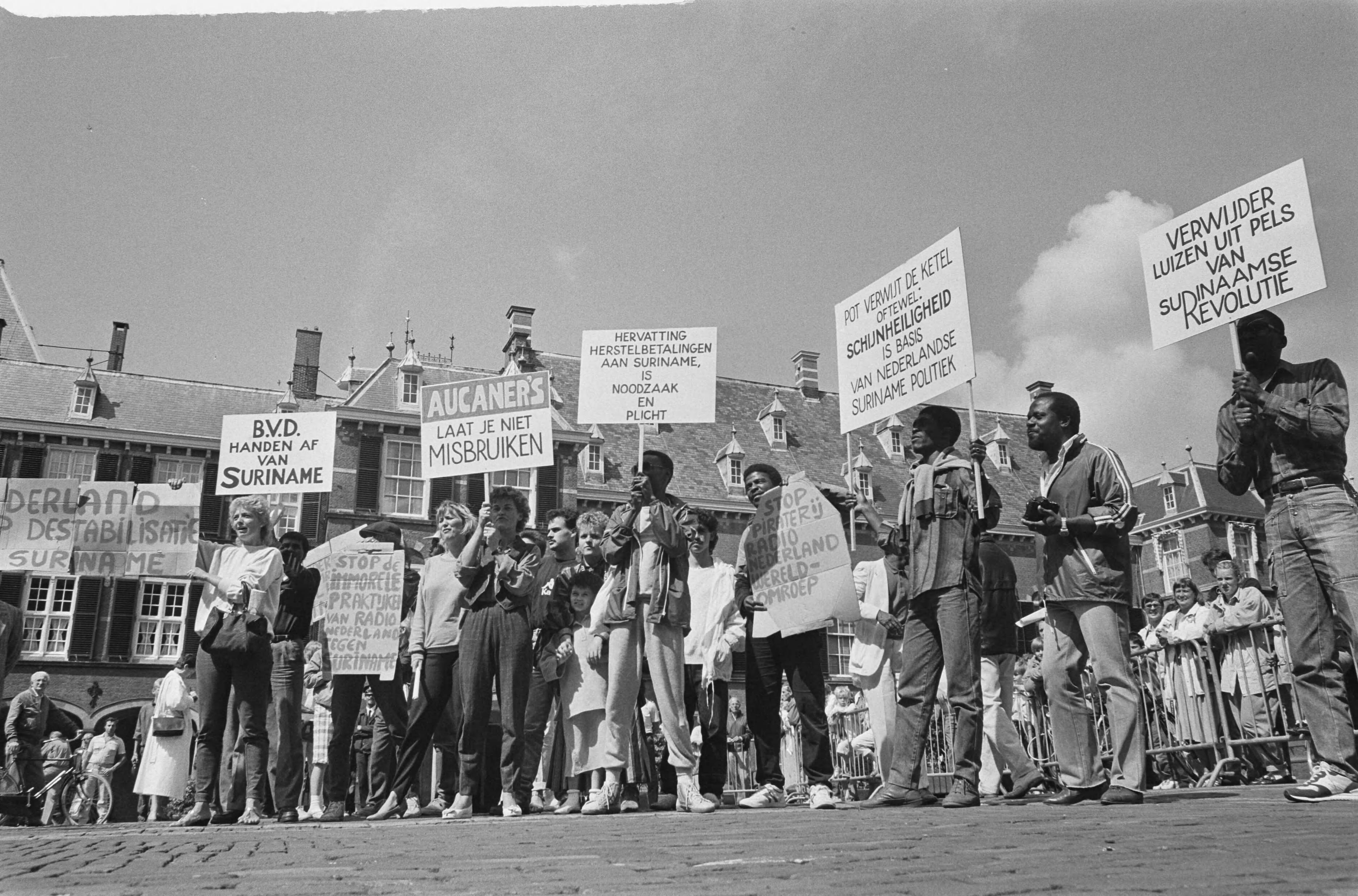 Fotocollectie Anefo — Pro Bouterse bijeenkomst in Den Haag ; remonstranten en van Mulier op Binnenhof — Foto: Croes, Rob C. / Anefo. Licentie: Set B: Rechtenvrij / Publiek Domein. Bron: Nationaal Archief. http://hdl.handle.net/10648/ad55d88a-d0b4-102d-bcf8-003048976d84