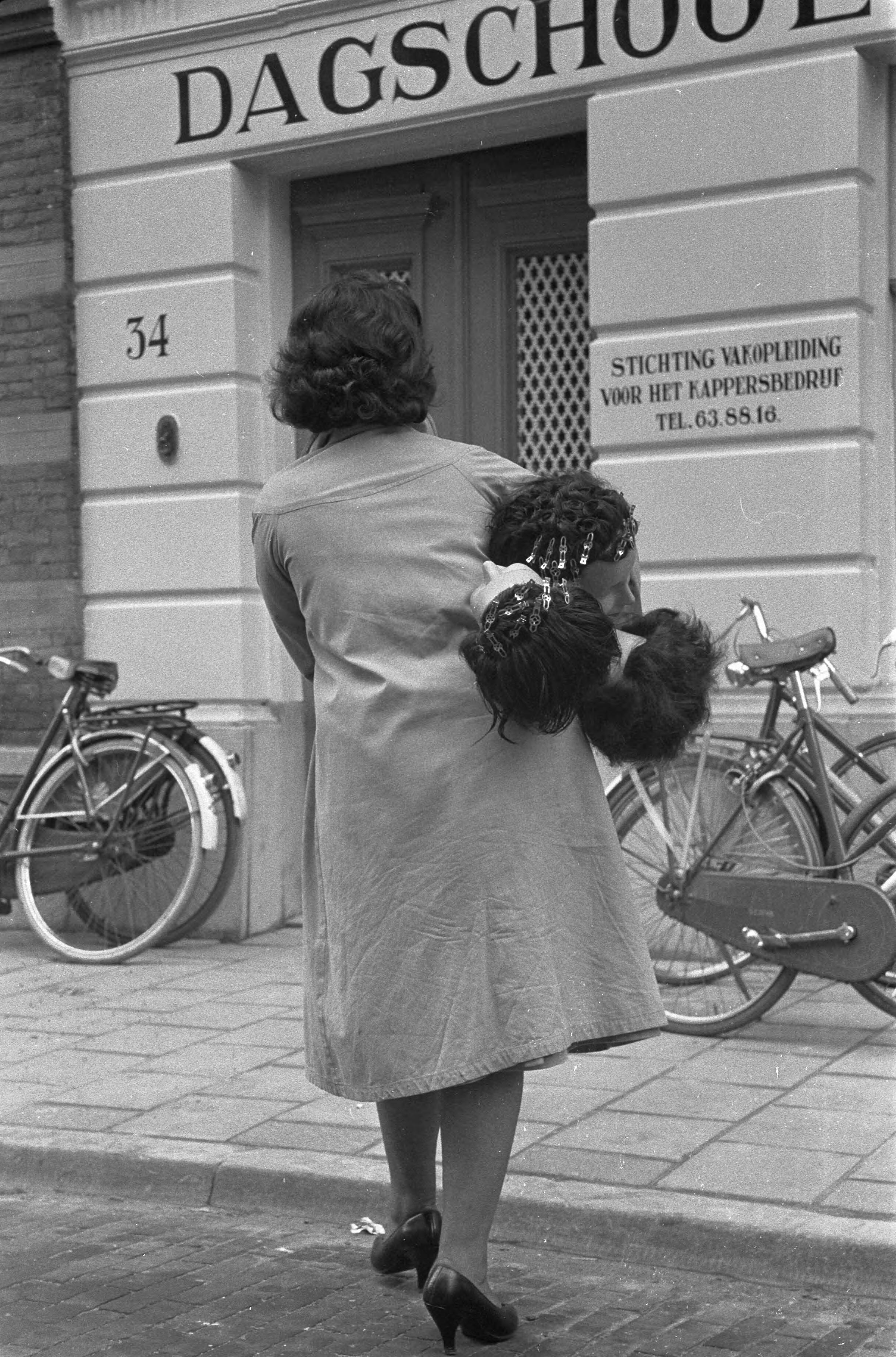Fotocollectie Anefo — Opening van de eerste kappersdagschool aan de Prinses Marijkestraat te Den Haag — Foto: Pot, Harry / Anefo. Licentie: Set B: Rechtenvrij / Publiek Domein. Bron: Nationaal Archief. http://hdl.handle.net/10648/a9a90bc6-d0b4-102d-bcf8-003048976d84