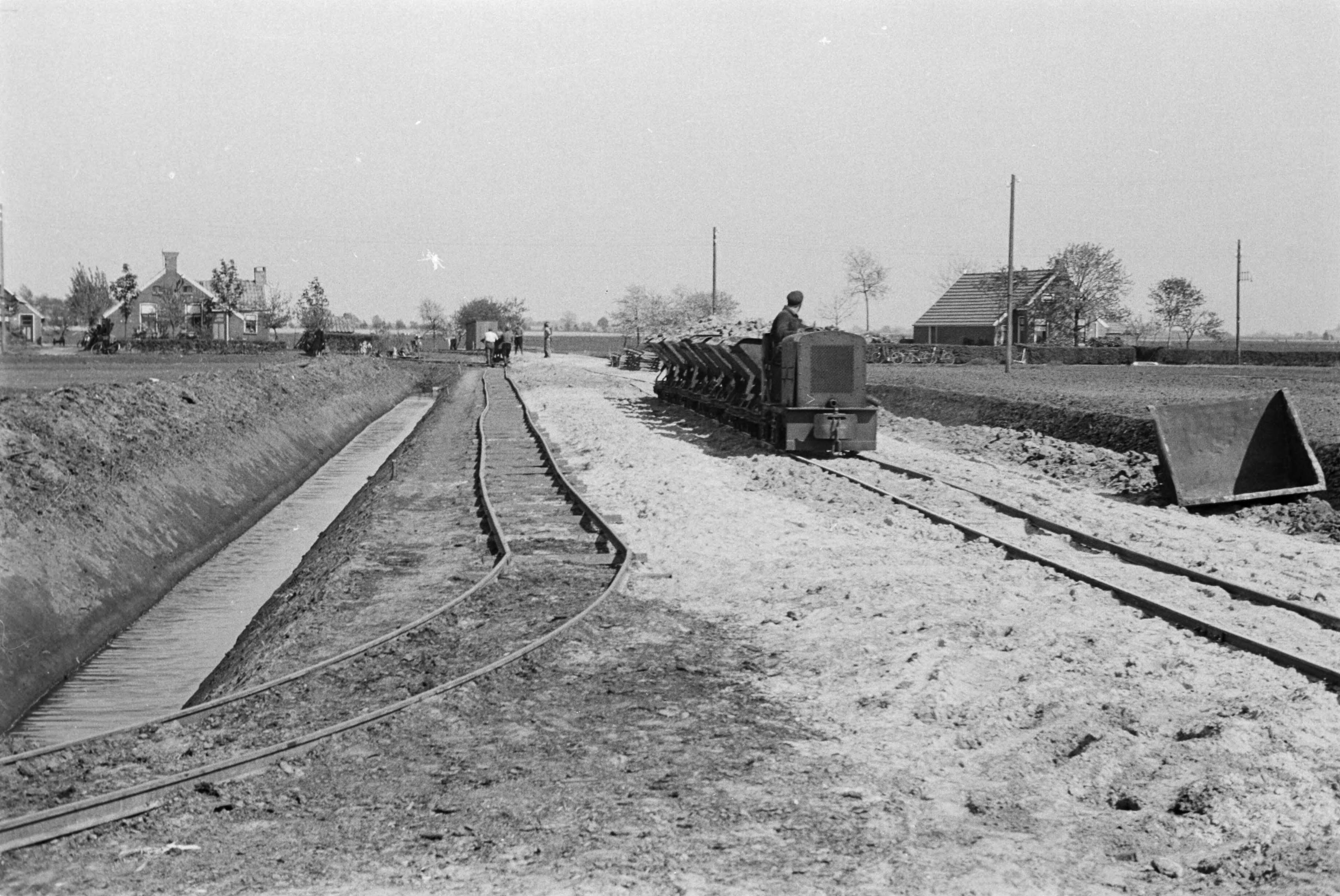 Fotocollectie Nederlandse Heidemaatschappij — Midwolda|arbeiders |kipkarren |trams |aanleg wegen|Groningen — Foto: Fotograaf Onbekend / Heidemij. Licentie: Set B: Rechtenvrij / Publiek Domein. Bron: Nationaal Archief. http://hdl.handle.net/10648/ae891a64-d0b4-102d-bcf8-003048976d84