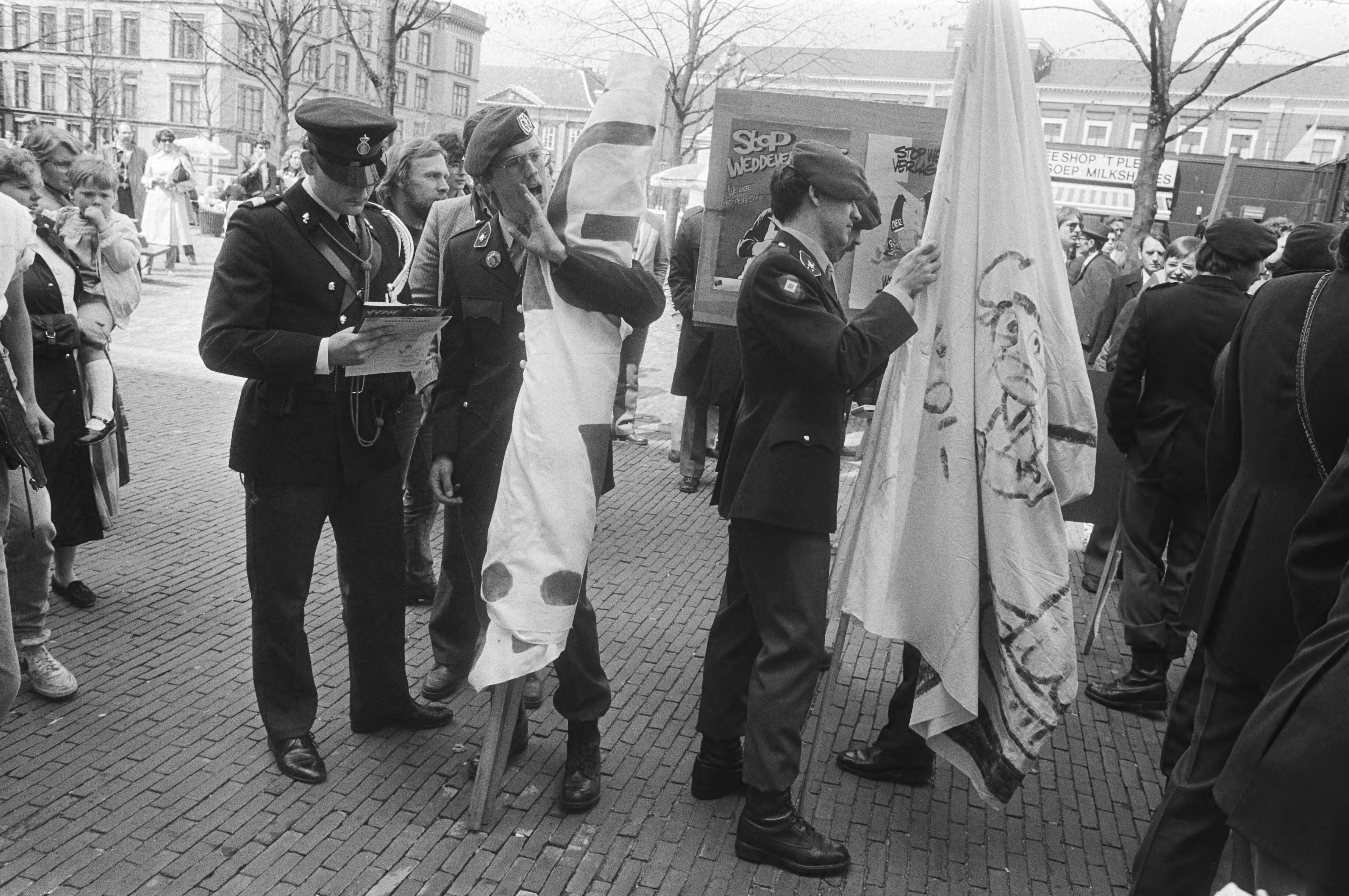 Protest van dienstplichtige militairen tegen weddeverlaging in Den Haag — Inbeslagname van spandoeken door de marechaussee — Foto: Bogaerts, Rob / Anefo. Licentie: Set B: Rechtenvrij / Publiek Domein. Bron: Nationaal Archief. http://hdl.handle.net/10648/ad289b54-d0b4-102d-bcf8-003048976d84
