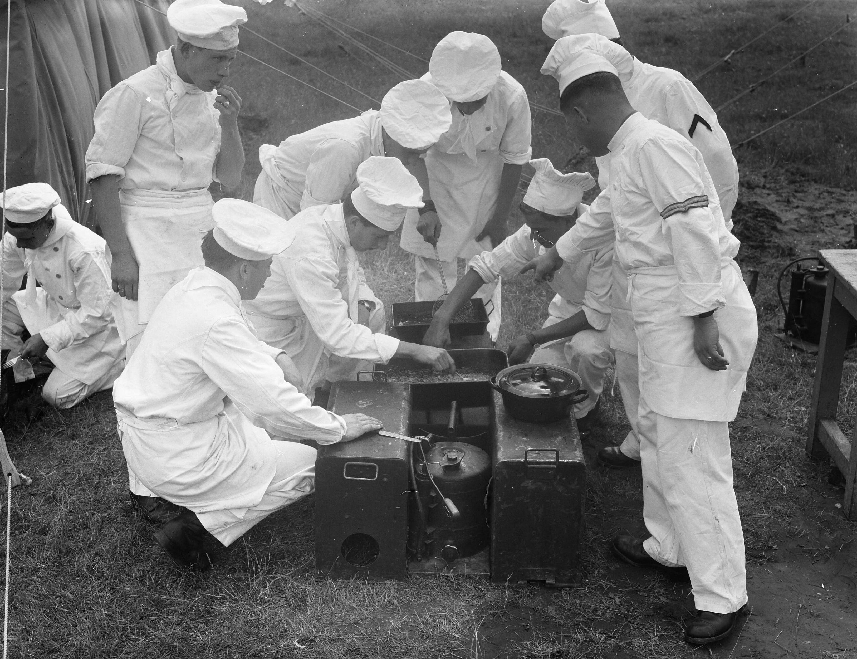 Fotocollectie Anefo — Militaire koks te Eelde koken in de buitenlucht — Foto: Merk, Ben / Anefo. Licentie: Set B: Rechtenvrij / Publiek Domein. Bron: Nationaal Archief. http://hdl.handle.net/10648/a8b9269c-d0b4-102d-bcf8-003048976d84